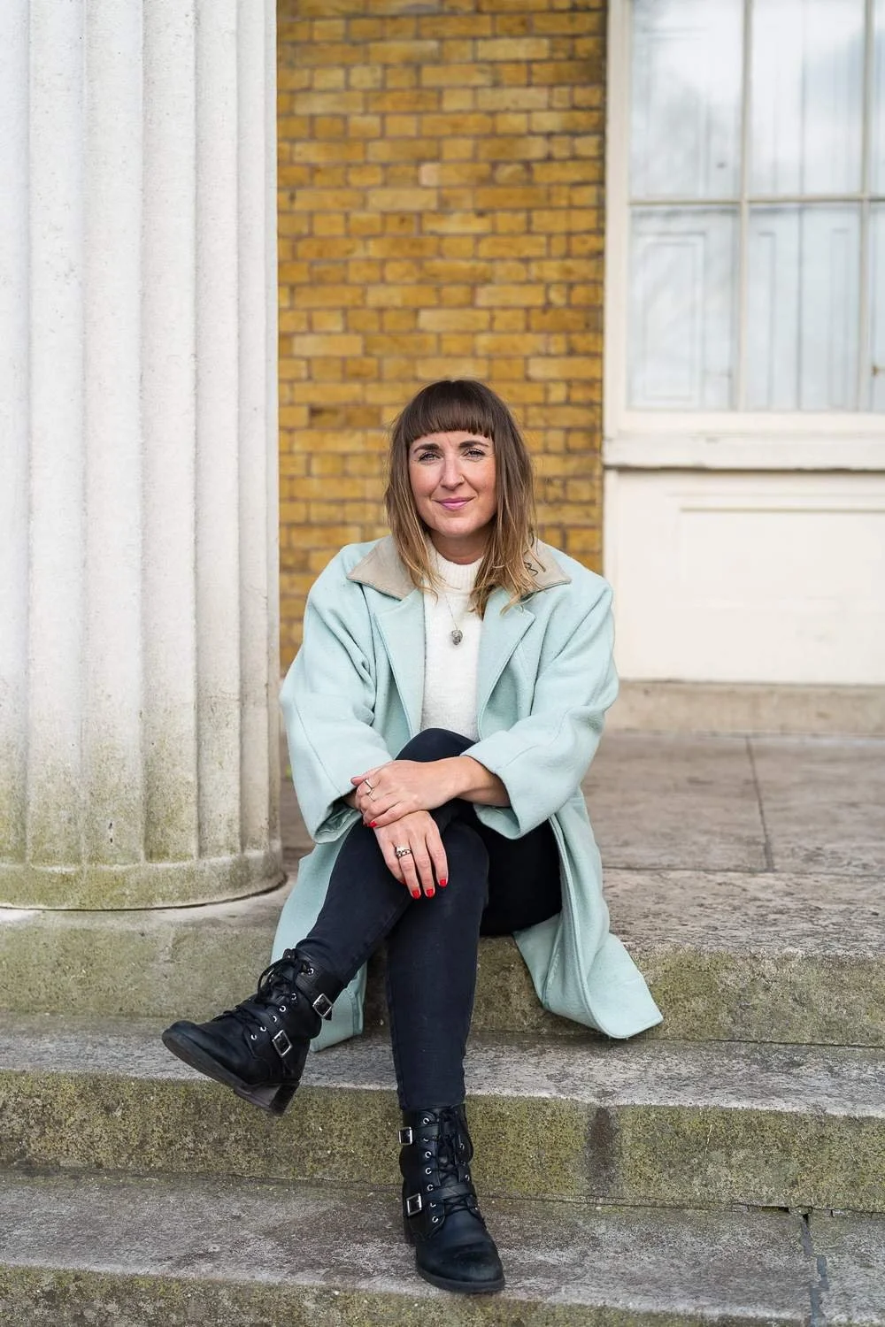 Dr Stephanie Minchin seated on stone steps outside a London building