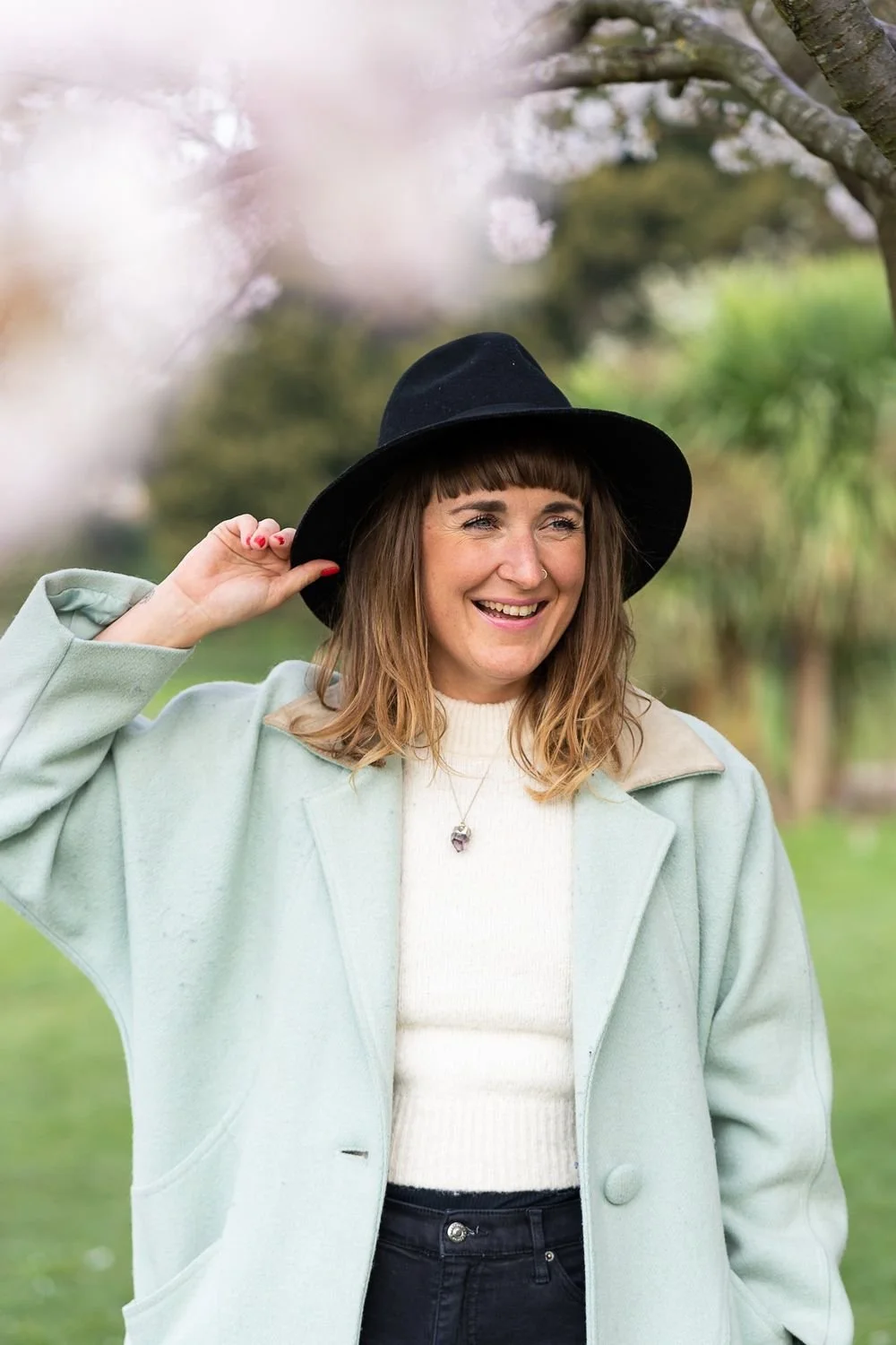 Dr Stephanie Minchin outdoors in a hat and mint coat, smiling to camera