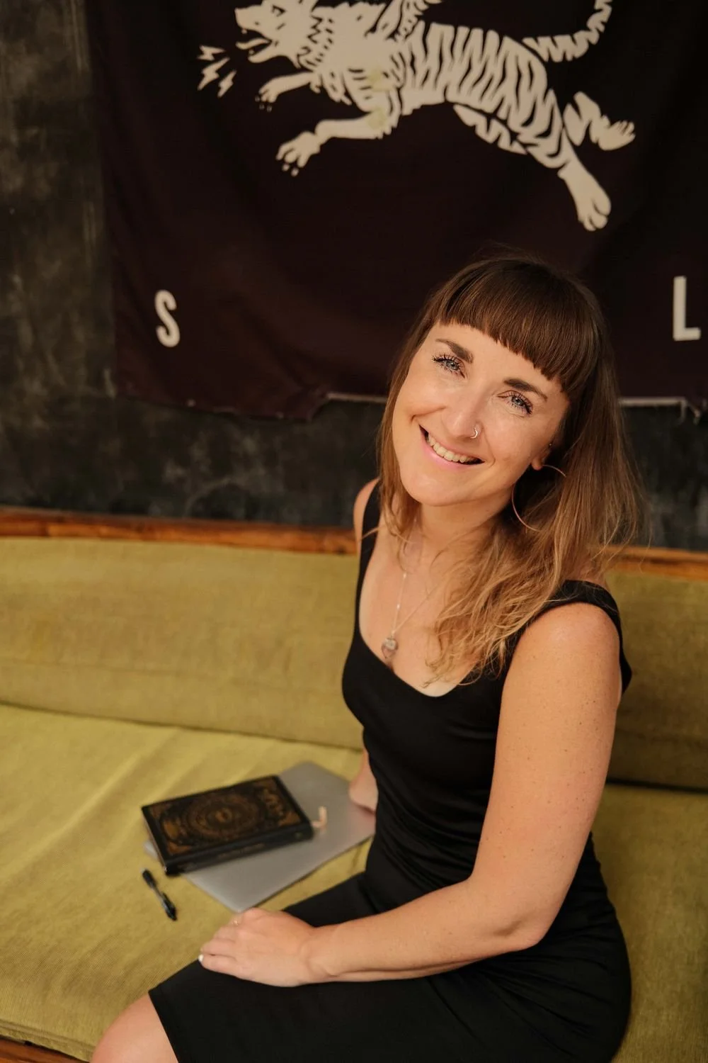 Dr Stephanie Minchin seated with a journal, smiling to camera