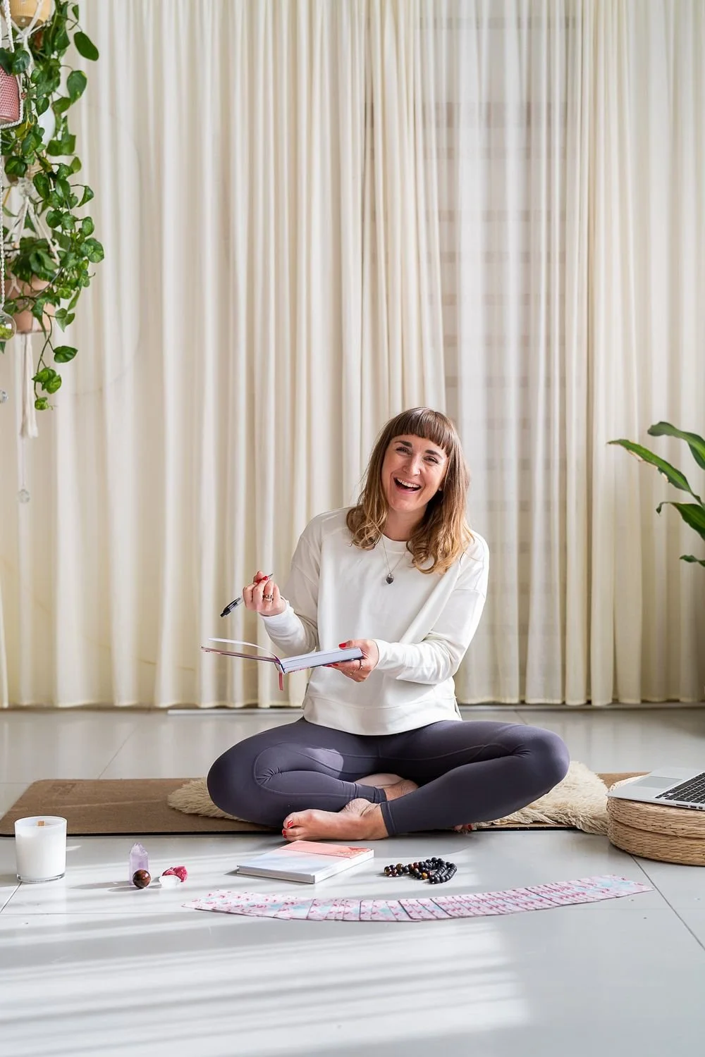Dr Stephanie Minchin seated cross legged with a journal and reflection cards