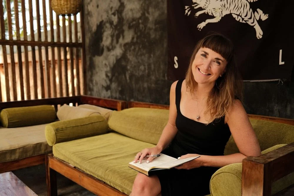 Dr Stephanie Minchin journalling on a sofa in a warmly lit room