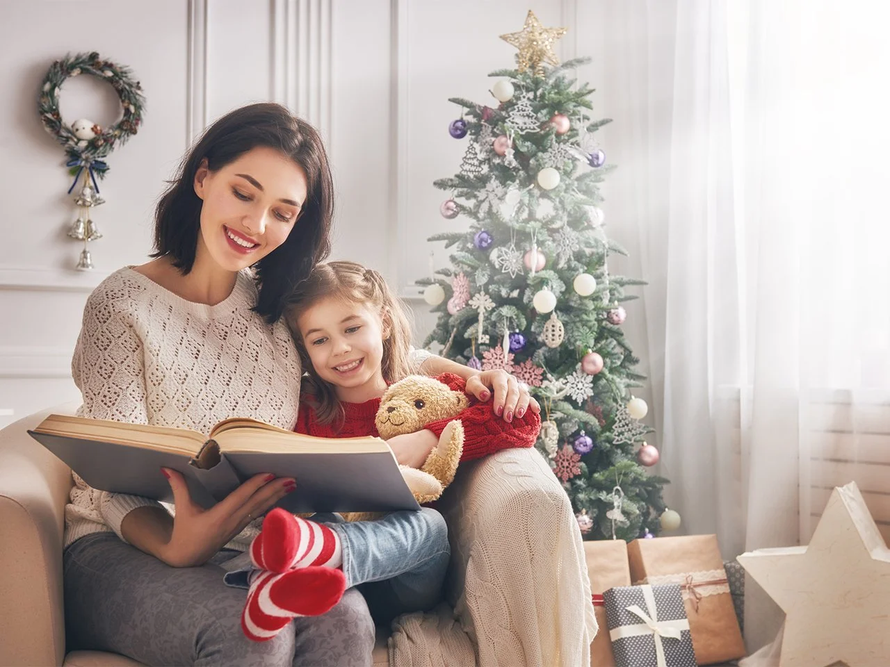 Parent reading a Christmas book to toddler to support early speech development