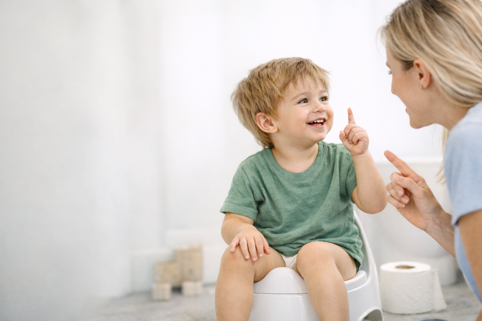 A toddler engages with a caregiver during a potty training routine, highlighting the importance of communication, connection, and caregiver support in speech therapy-informed potty training in Leander, Texas.