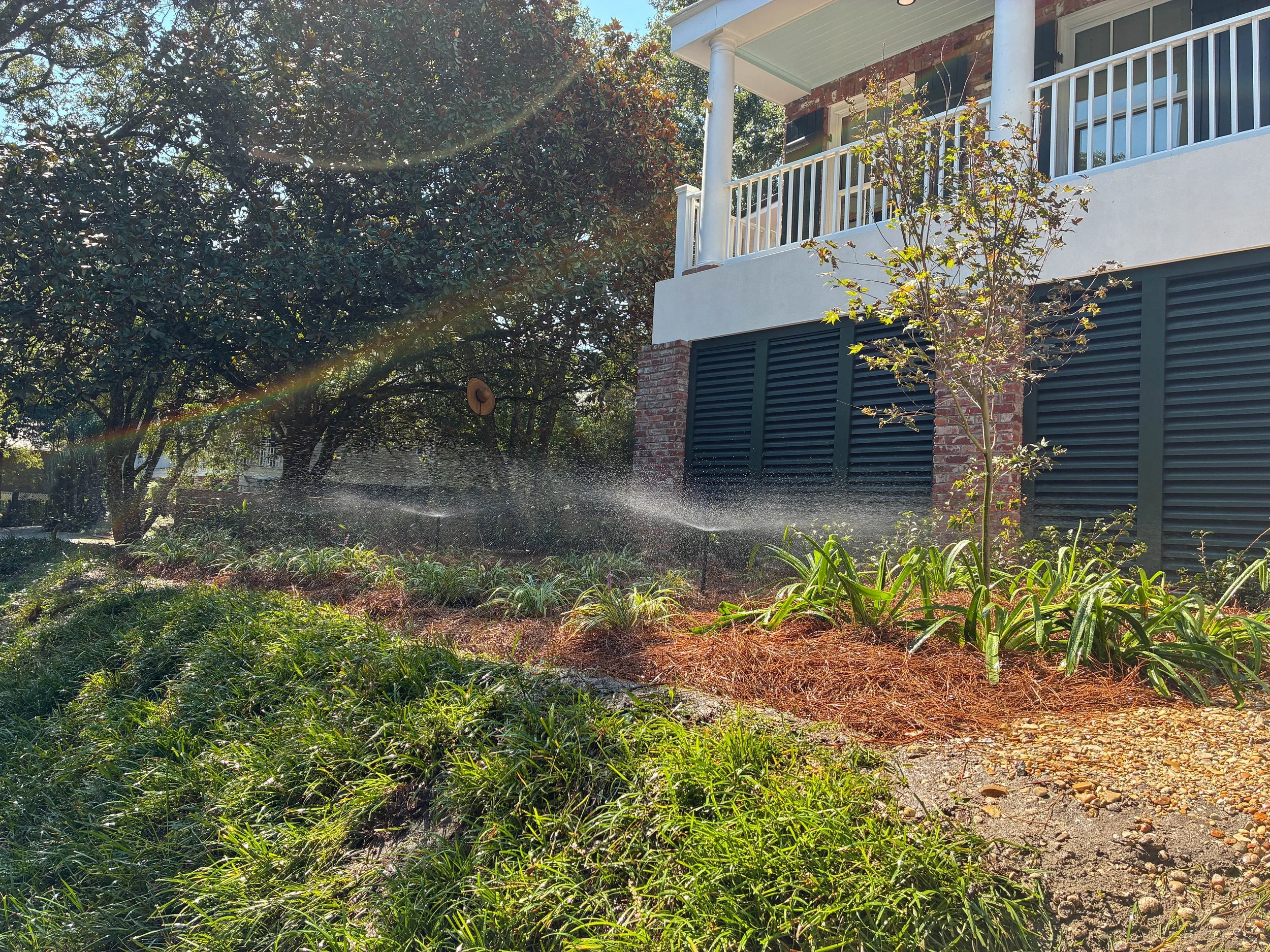 picture of garden bed that is elevated. sprinklers on causing a rainbow