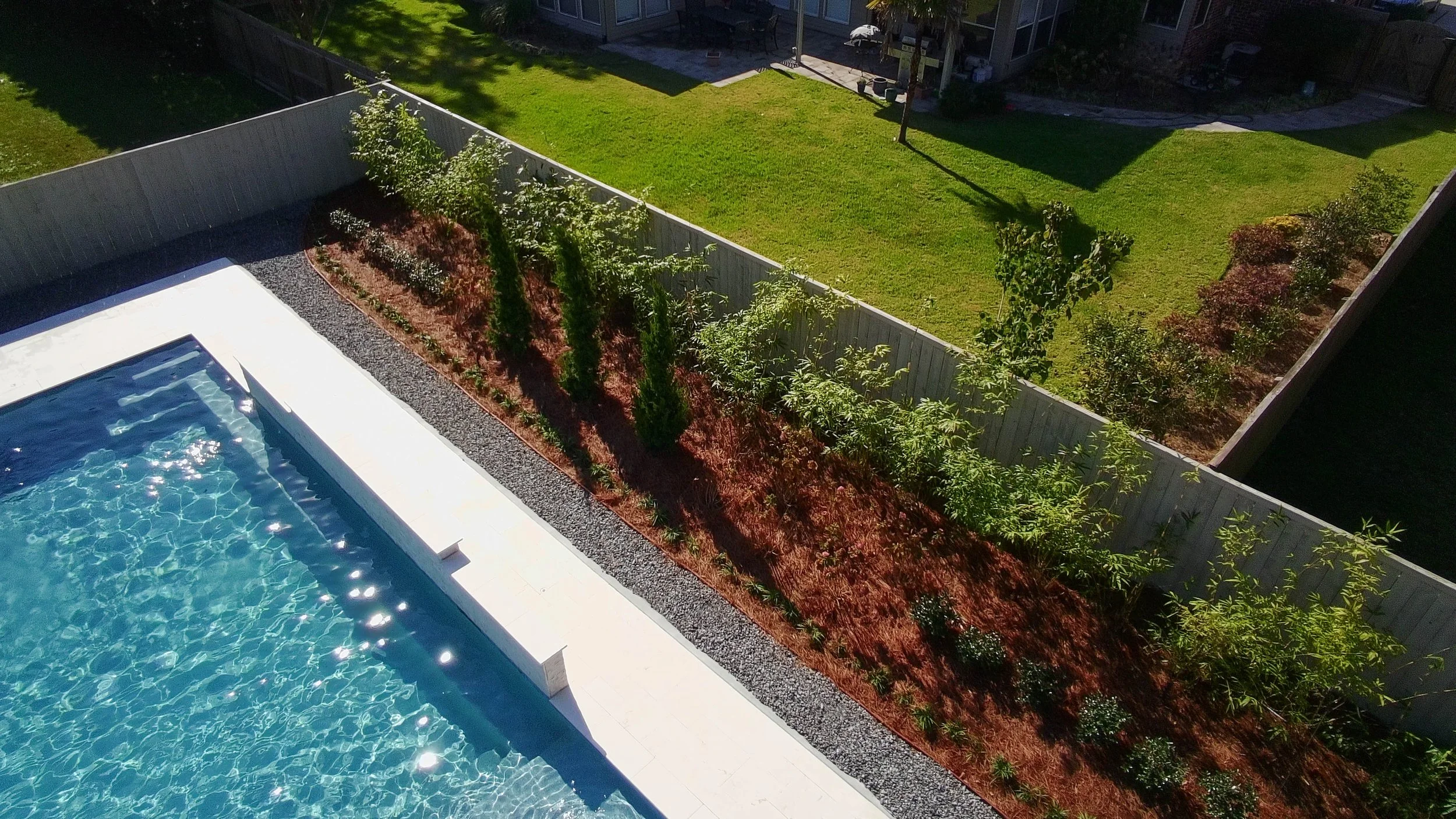 a drone picture of a garden bed by the pool