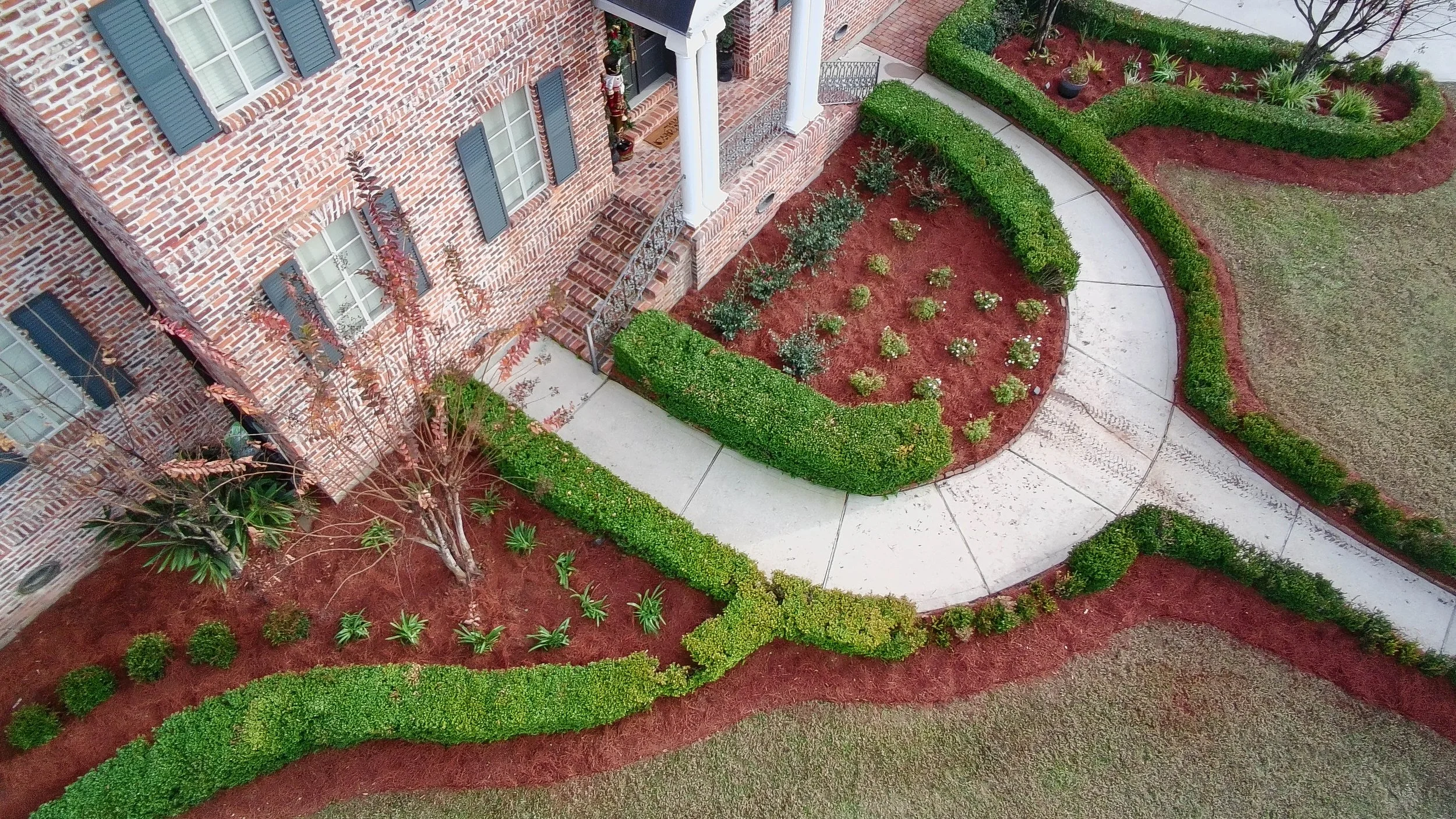 drone picture of another angle of the semi circle garden bed. has a boxwood hedge