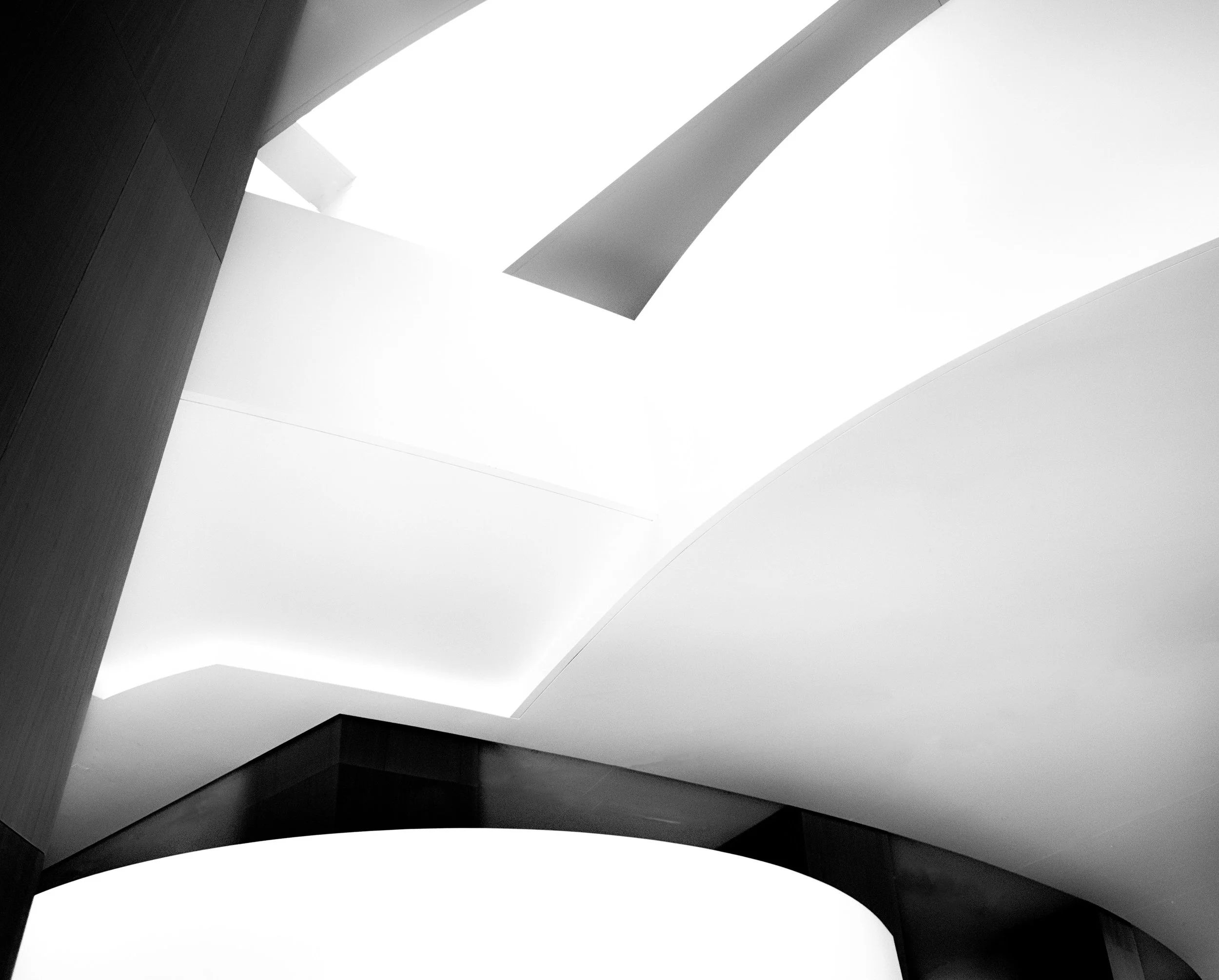 Black-and-white abstract view of angular modern architectural ceilings and geometric beams