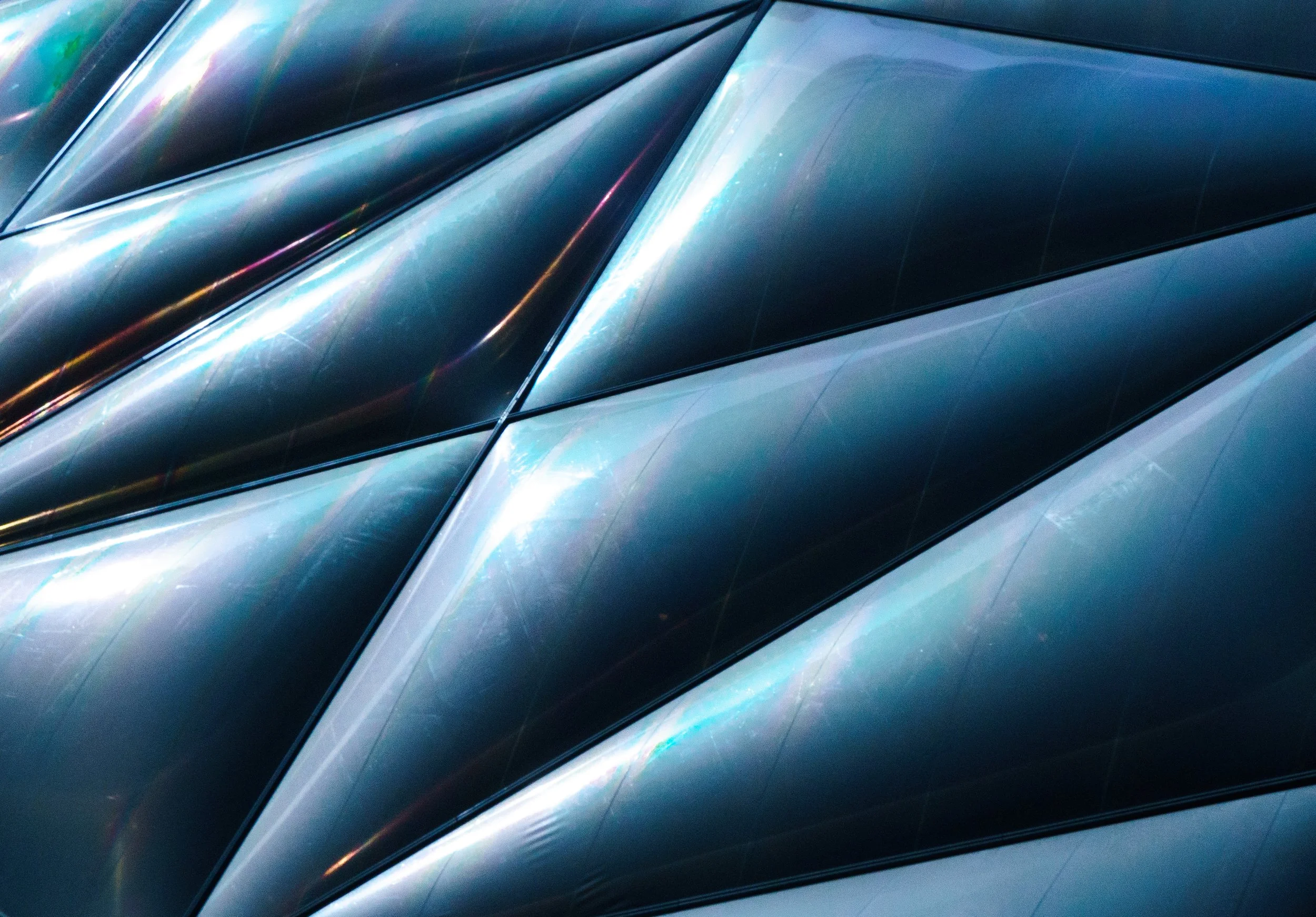 Abstract blue and silver metallic curved surfaces with reflective highlights