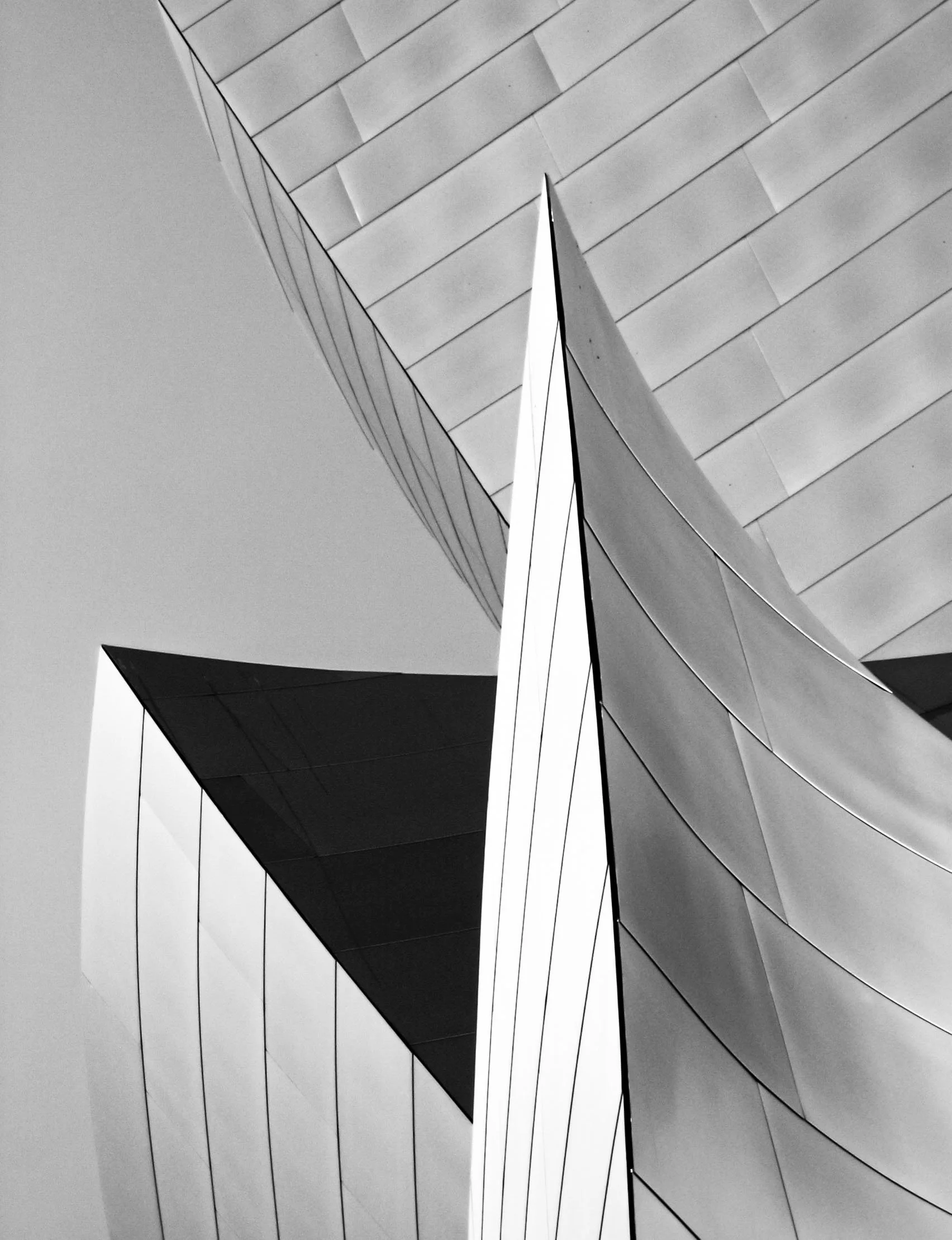 Black-and-white abstract photograph of modern architectural buildings with sharp geometric lines and layered facades