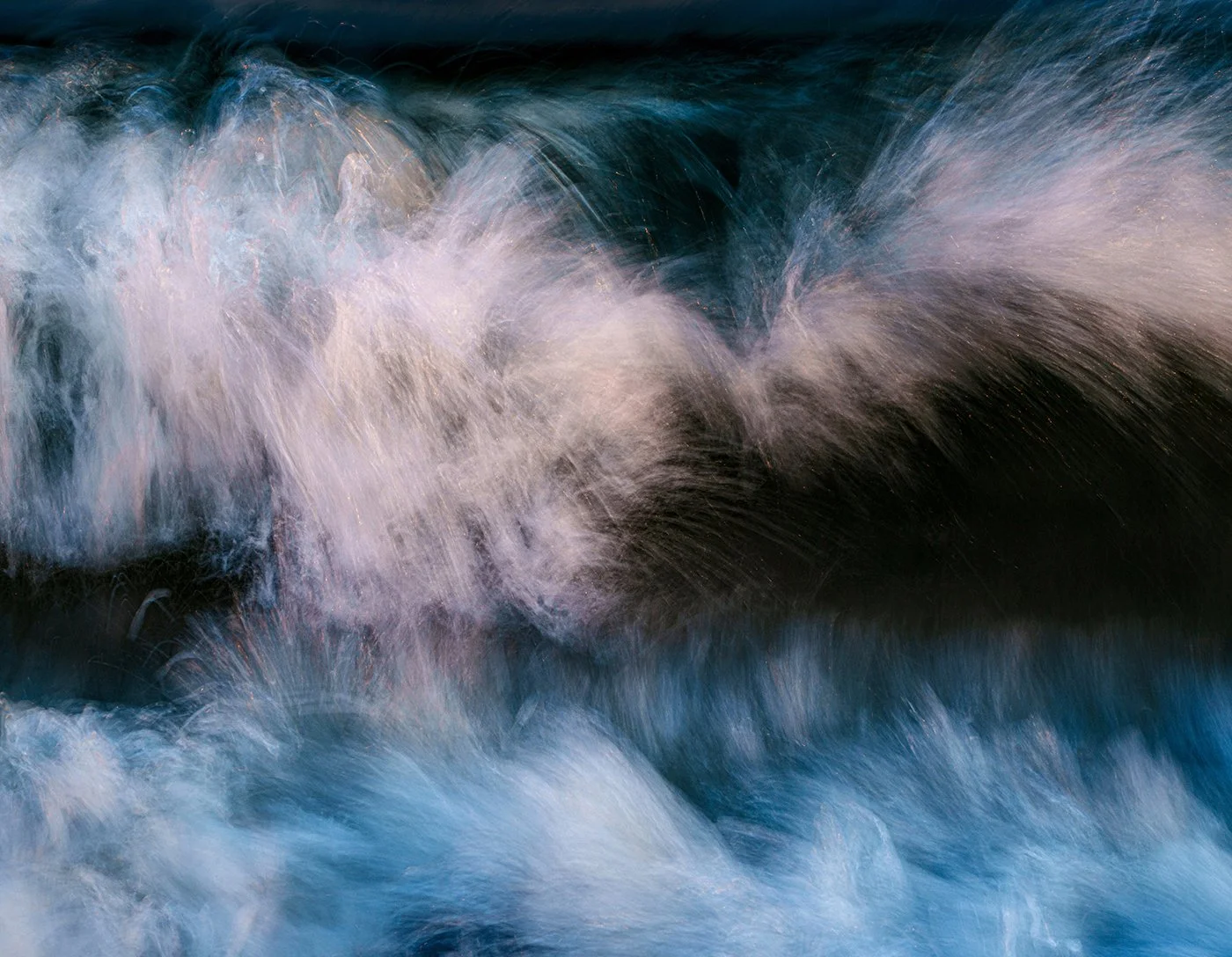 Abstract close-up of foamy blue and white ocean waves in motion