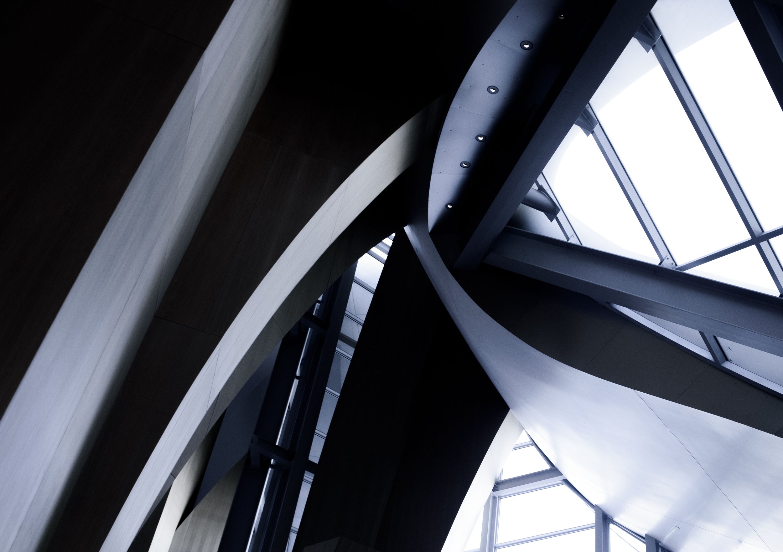 Abstract view of dark architectural beams and bright geometric skylights inside a modern building