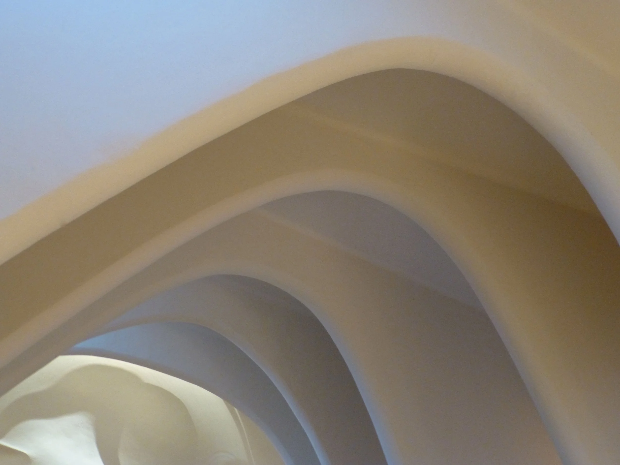 Abstract close-up of overlapping curved bands in soft blue, beige, and gray tones