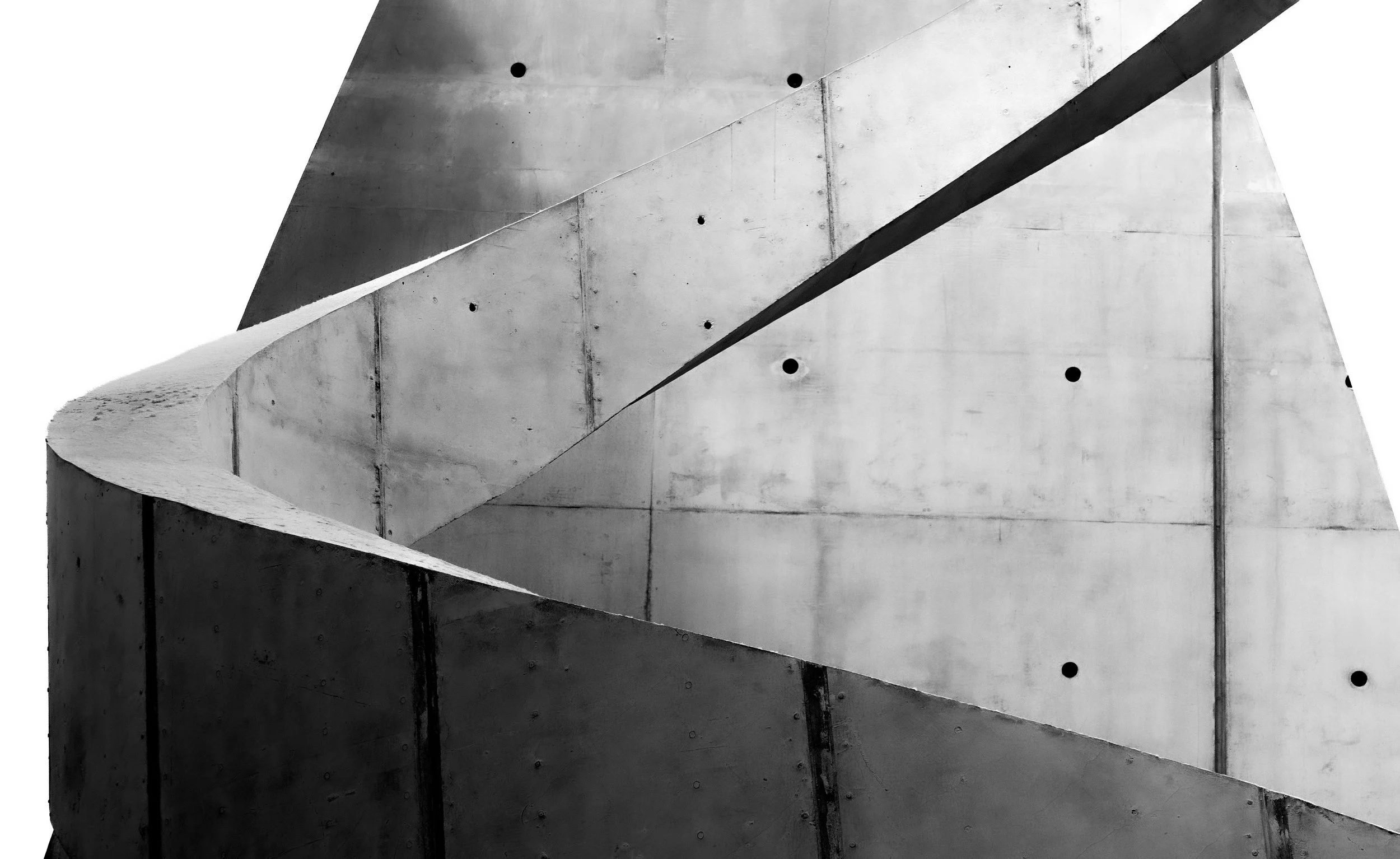 Abstract black-and-white architectural detail of angular metal panels with circular openings