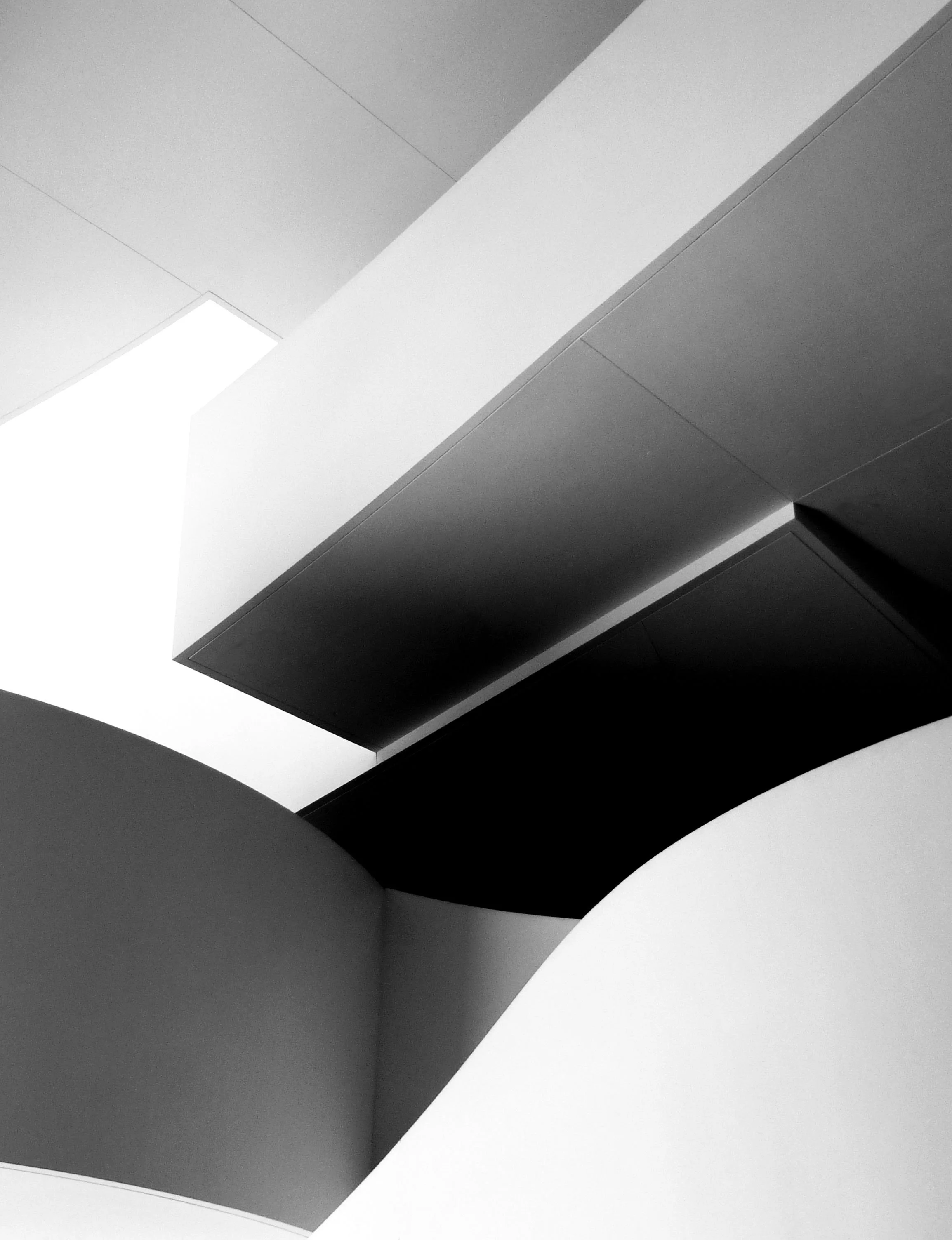 Abstract black-and-white geometric composition of overlapping angular planes and architectural shapes.