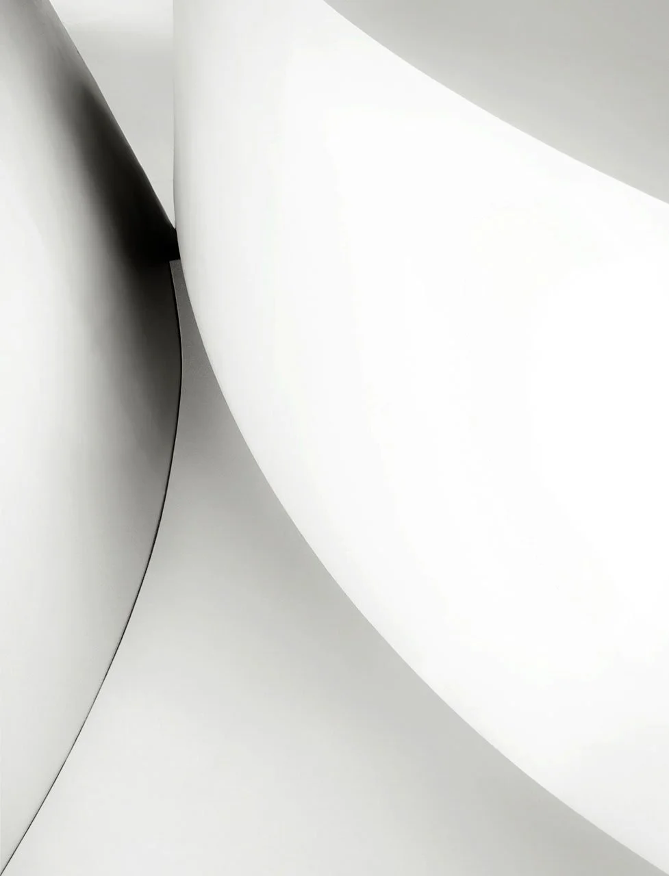 Abstract close-up of overlapping white curved surfaces with soft gray shadows