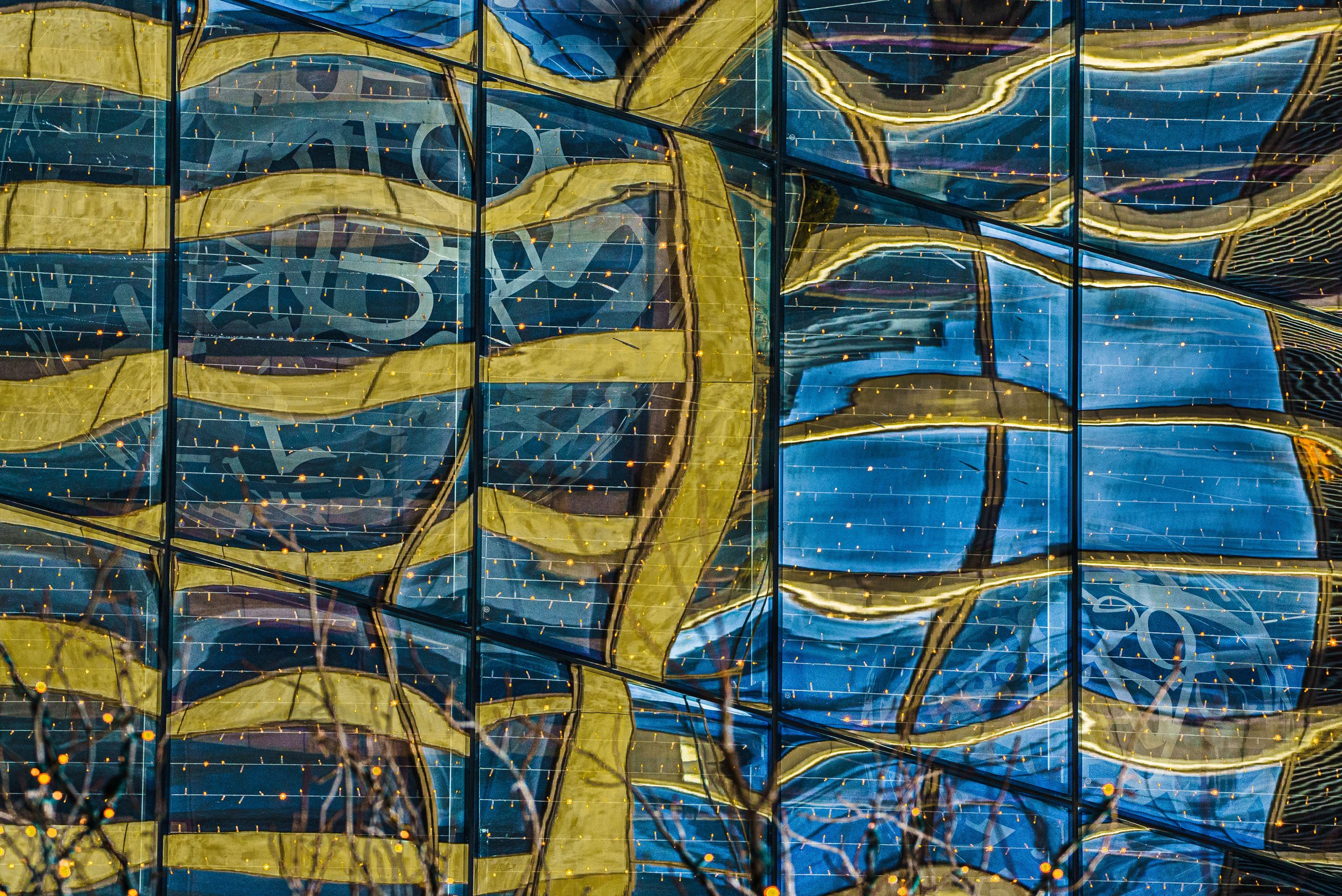 Abstract blue and gold geometric artwork with glowing orange dots and black grid lines