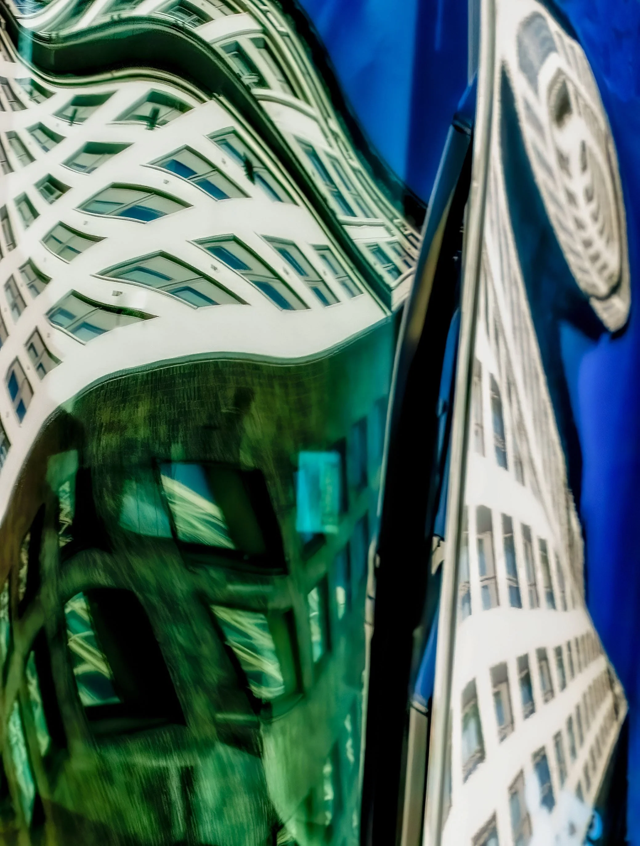 Abstract distorted reflection of a modern building facade and large black-and-white portrait against a vivid blue background