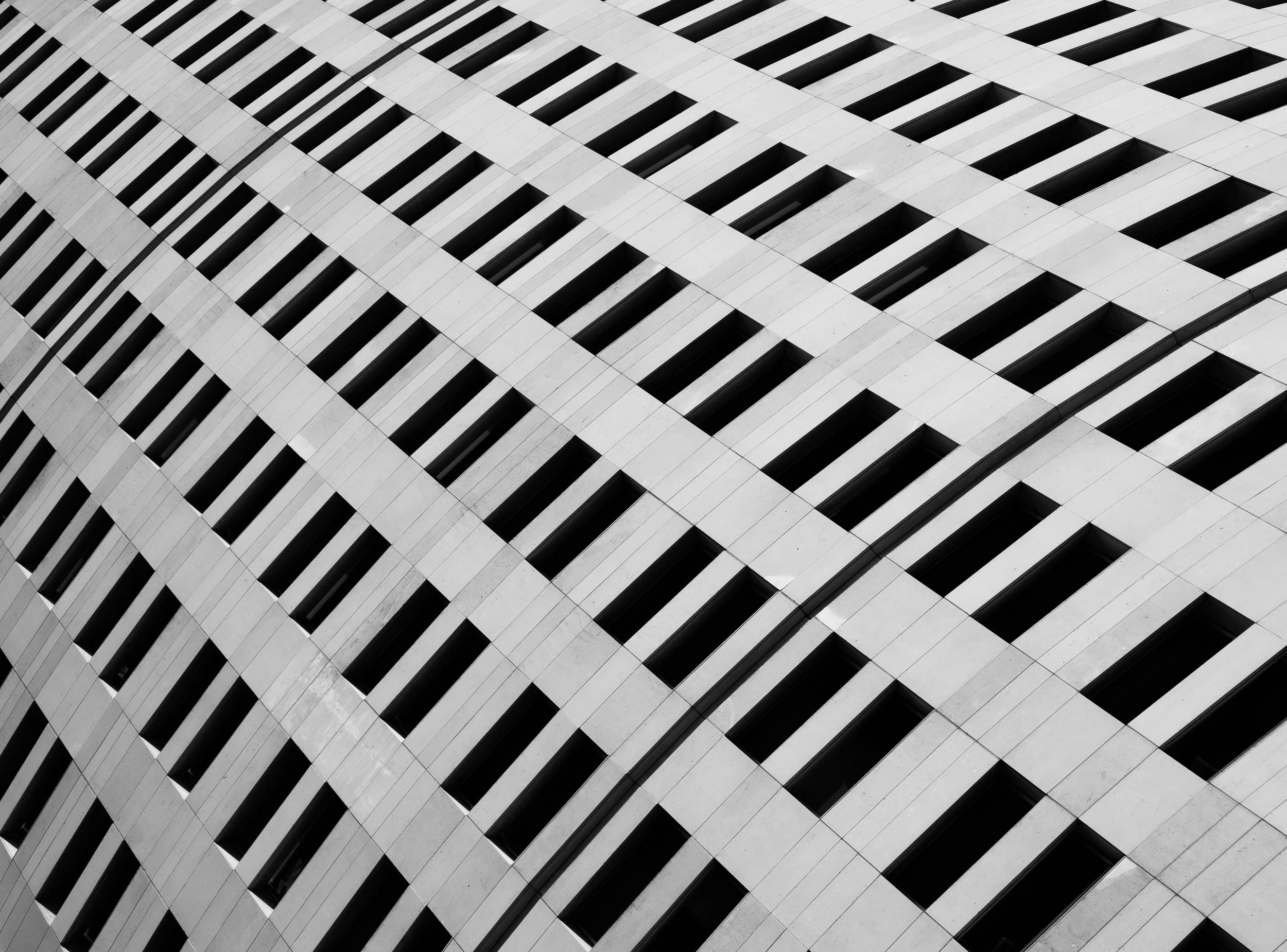 Black-and-white geometric view of a modern building facade with repeating rectangular windows