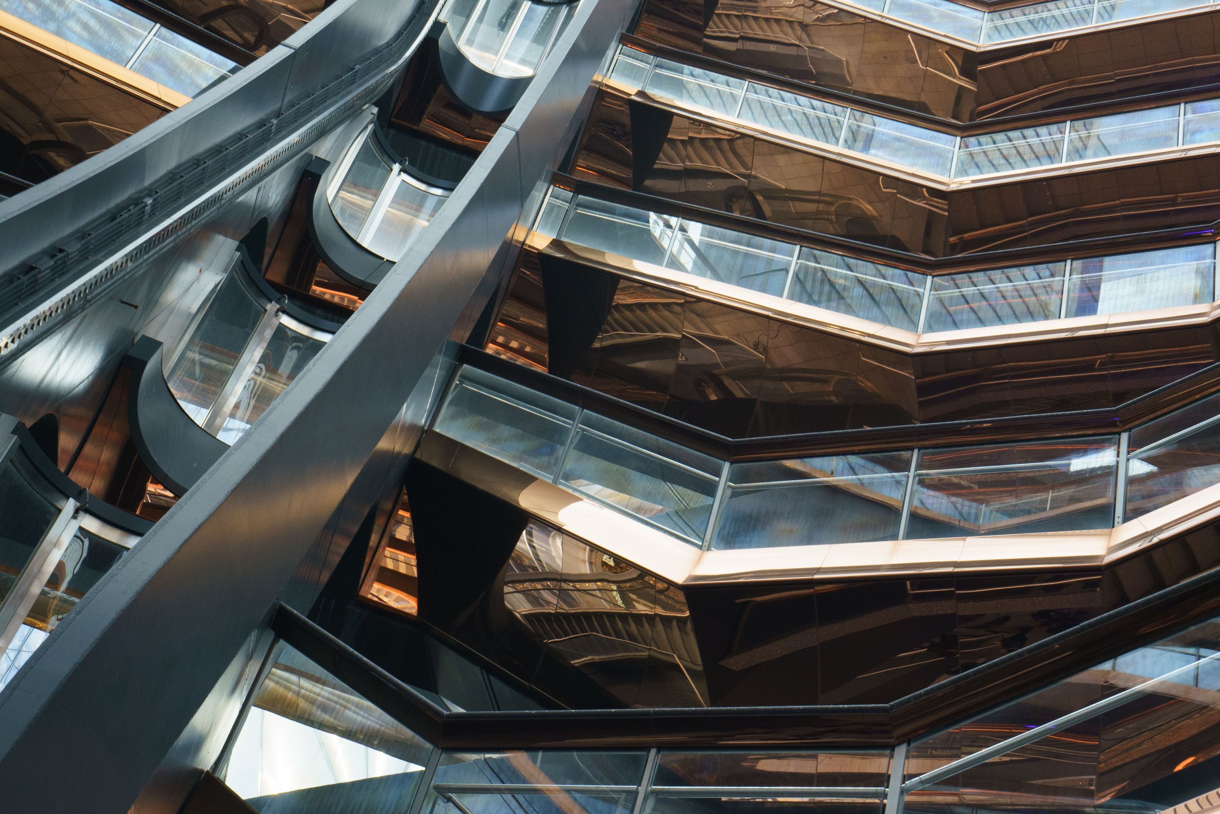 Abstract view of glass elevators and reflective metal walls in a modern building atrium
