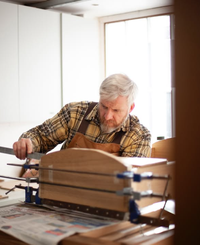 man doing a glue up of a carcass in a wood workshop