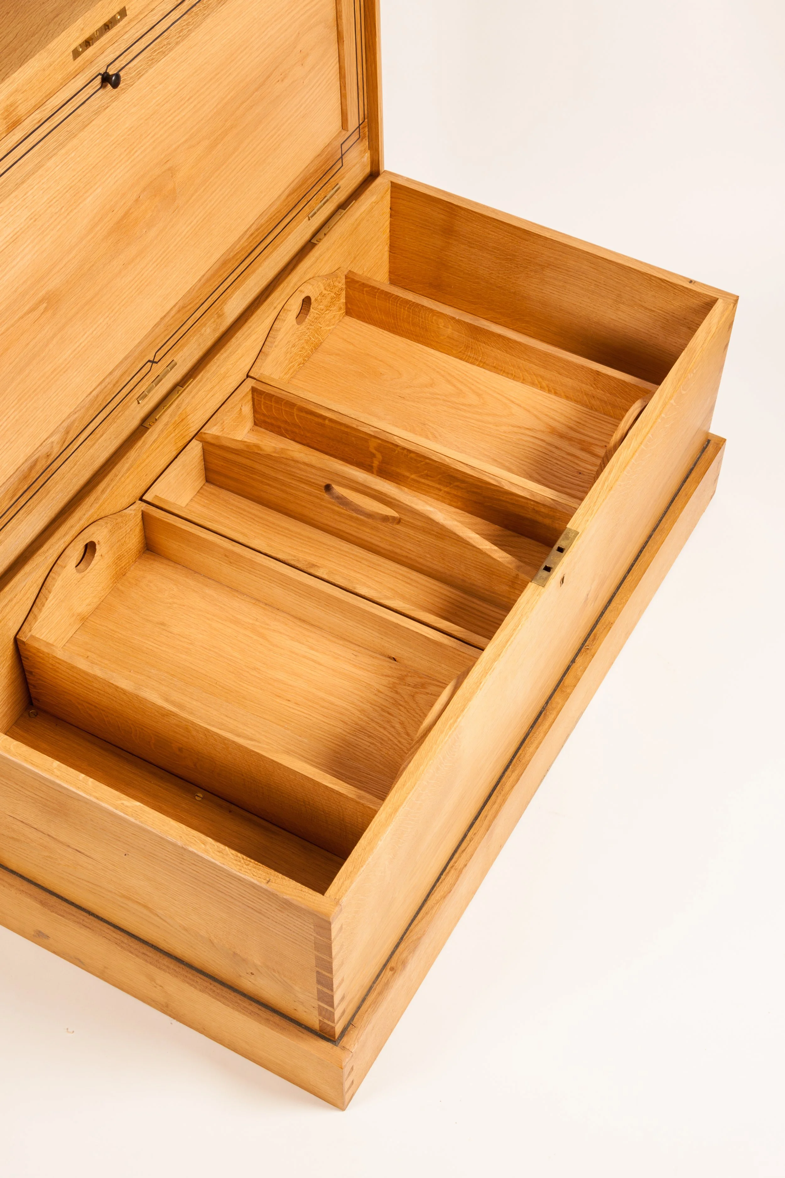 A wooden music box with open drawers, showing multiple compartments inside.