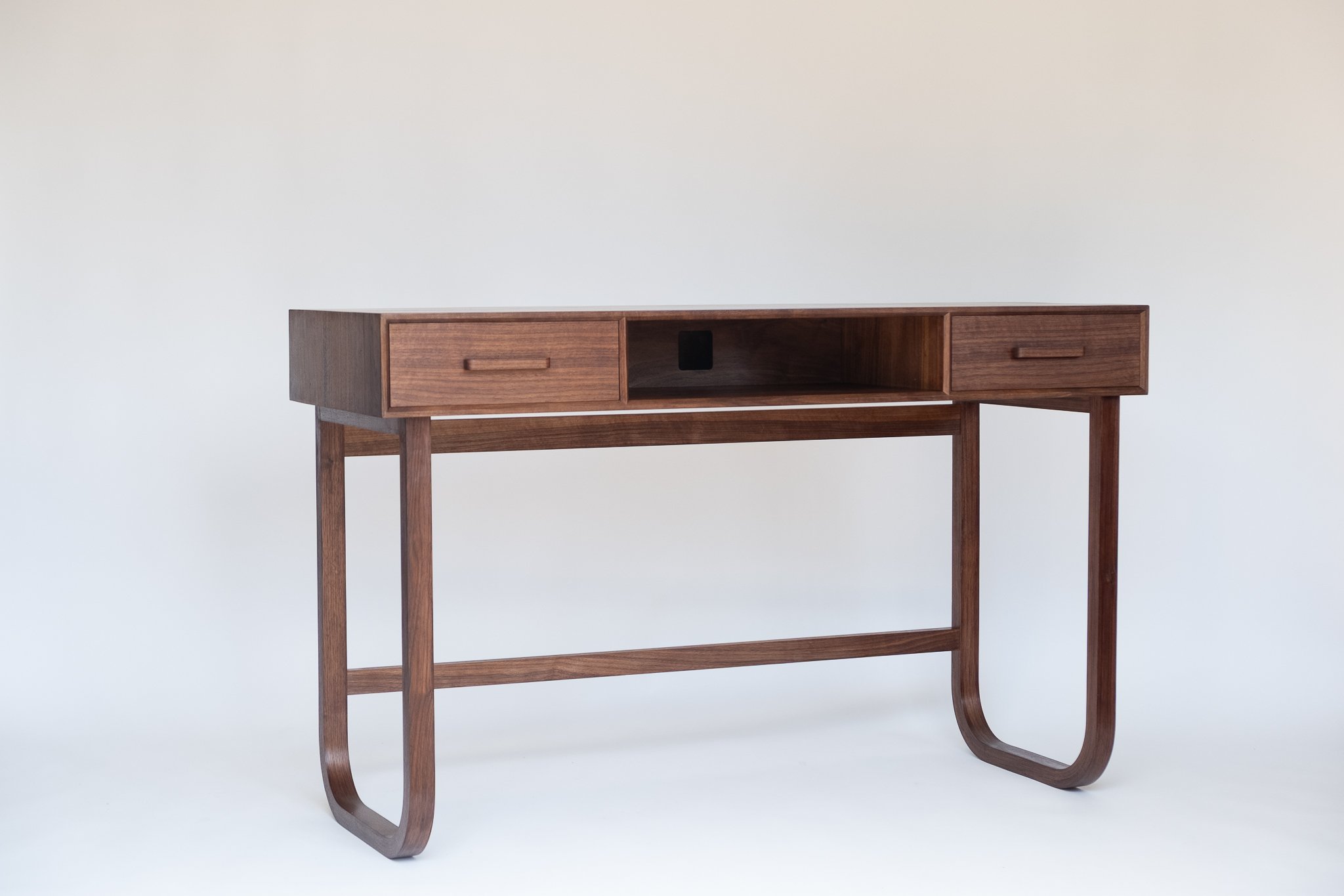 A mid-century modern wooden sideboard table with two drawers and an open storage area, supported by four slender legs and S-shaped curved supports.