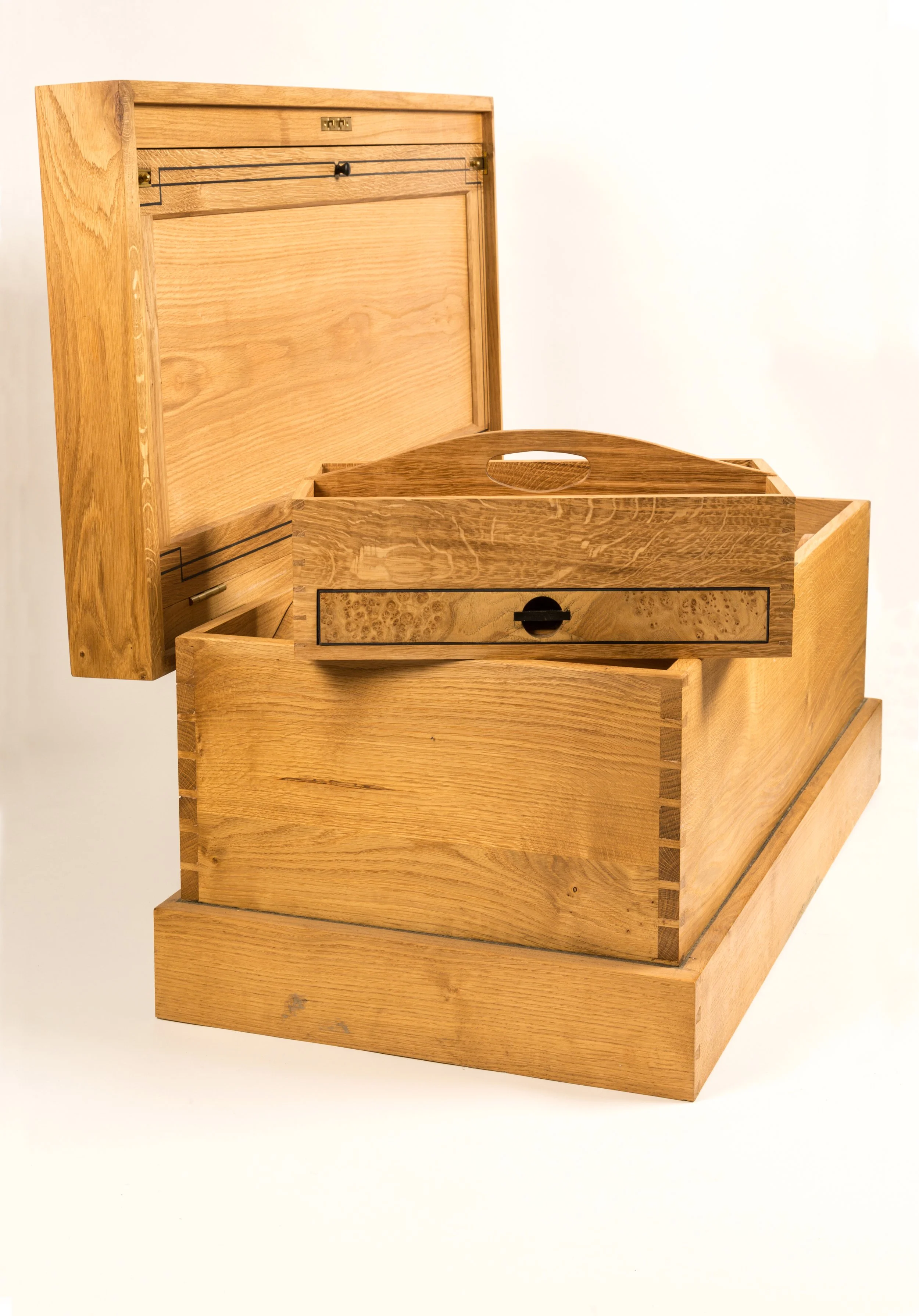 A wooden jewelry or storage box with a hinged lid, featuring a drawer with a small black handle, set against a plain white background.