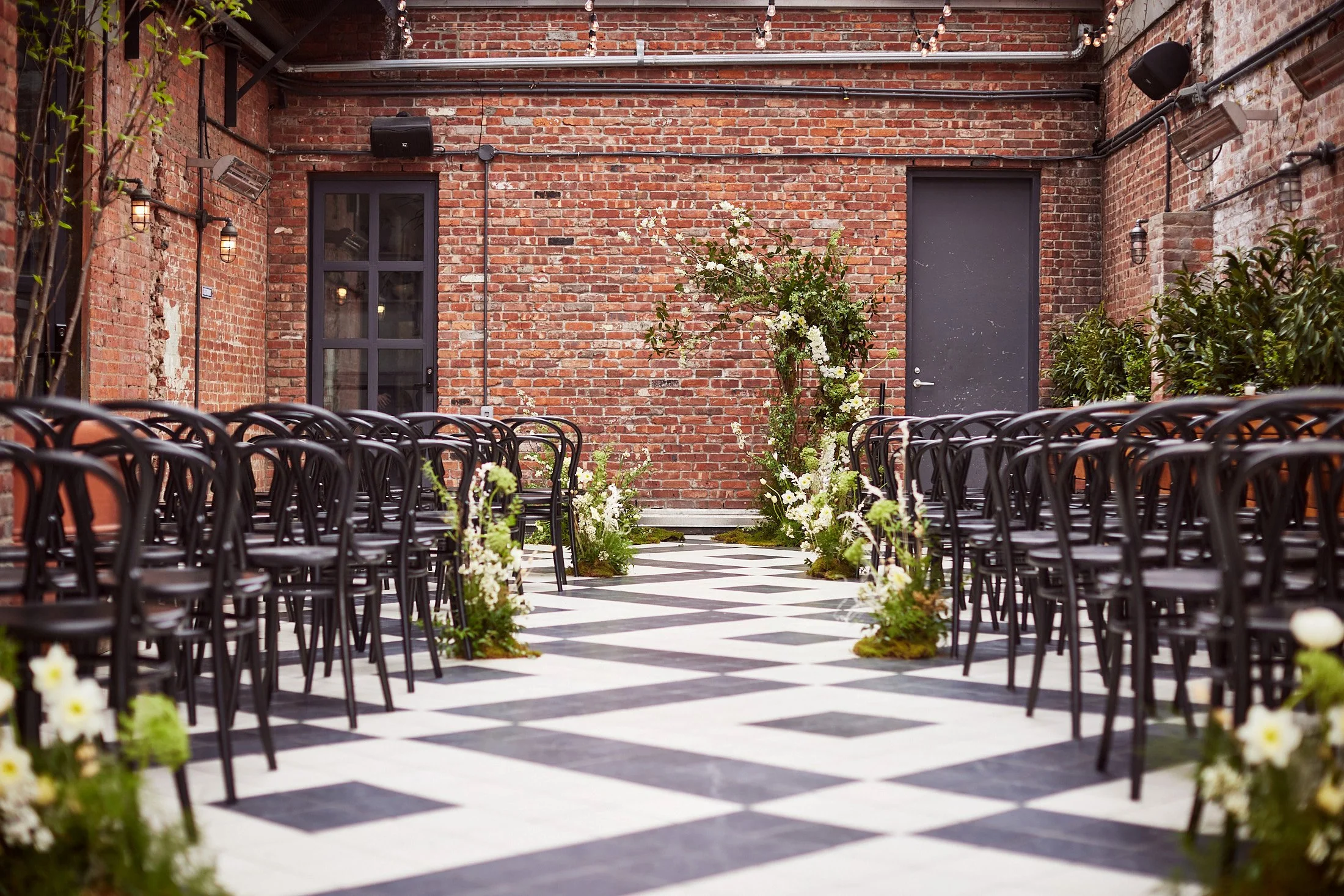 Brooklyn wedding ceremony at Wythe Hotel with florals and greenery