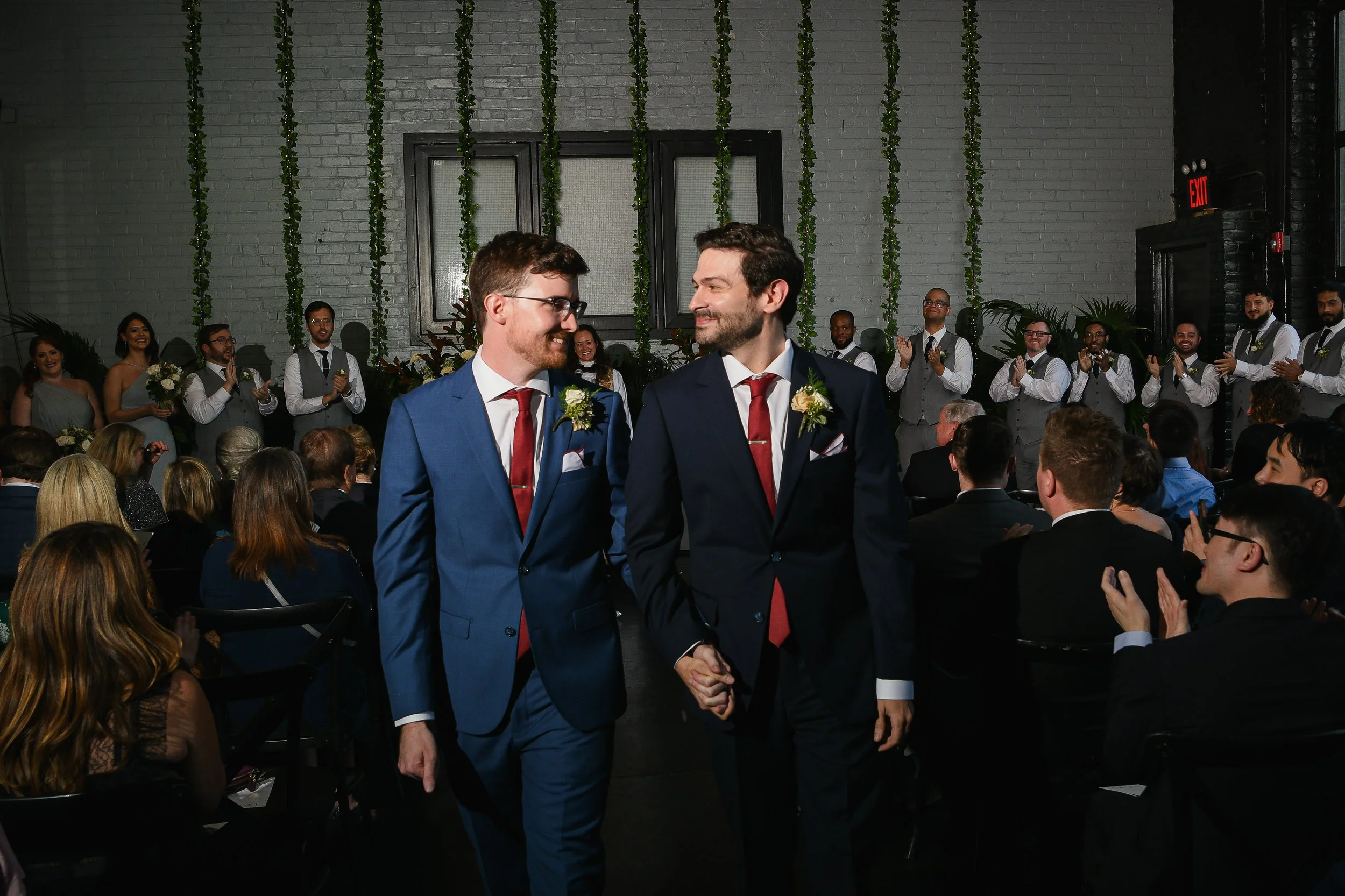 Two gay grooms wedding ceremony holding handss