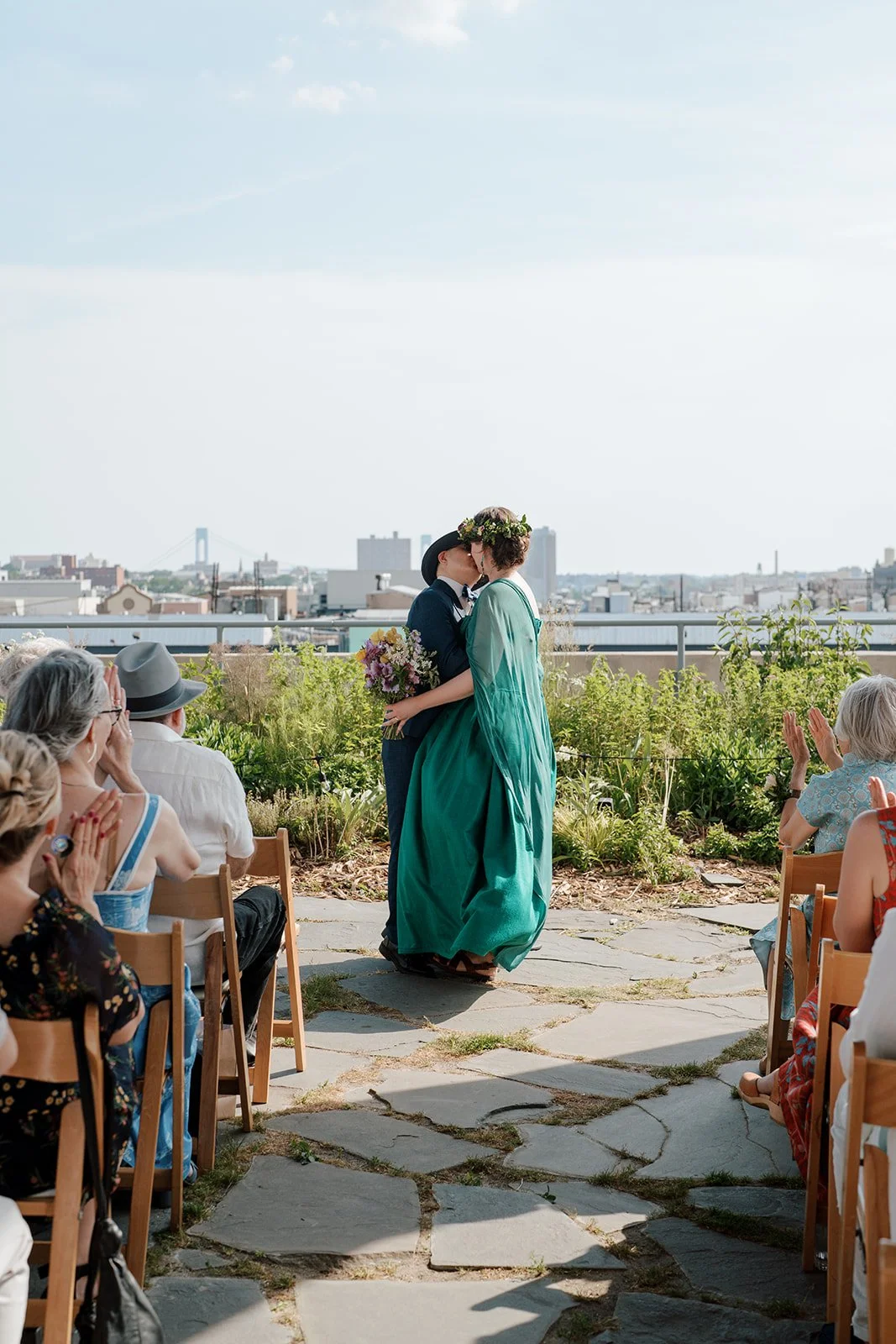 Couple kissing at rooftop Brooklyn wedding ceremony