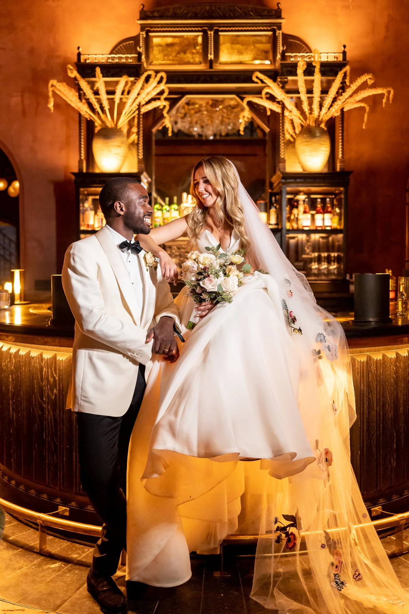 Bride and groom pose next to wedding bar in NYC