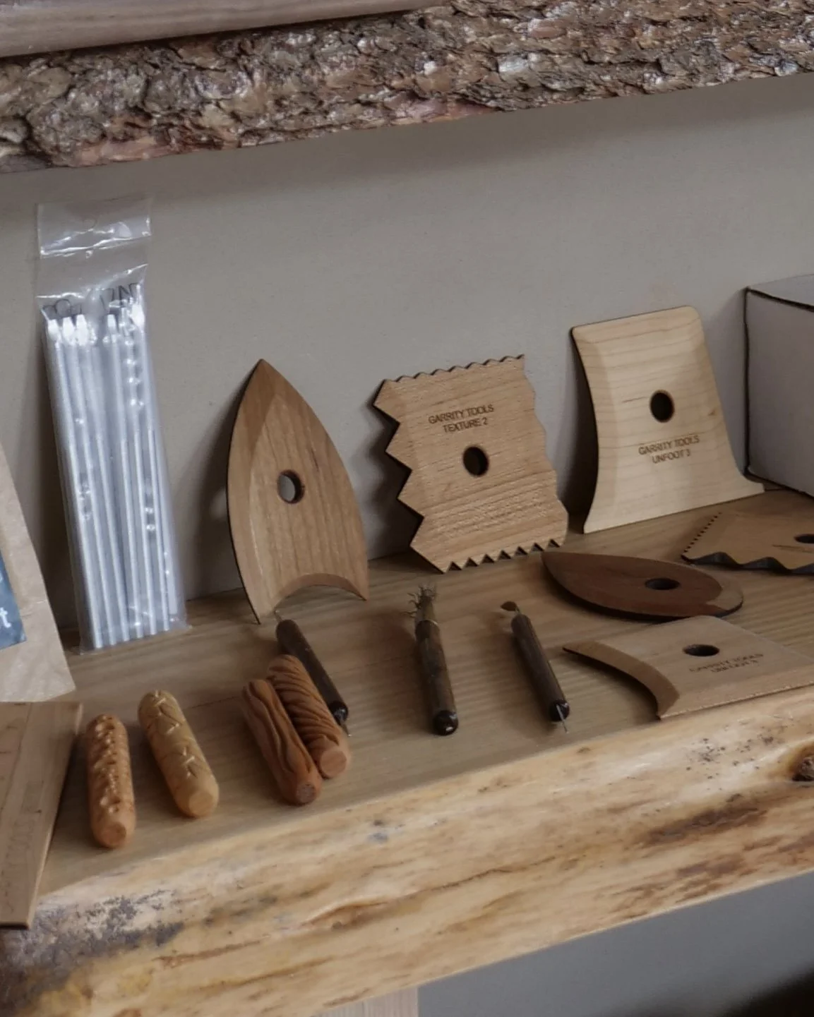 Wooden templates and planks of wood for crafting or woodworking, with some small wooden sticks, on a wooden table.