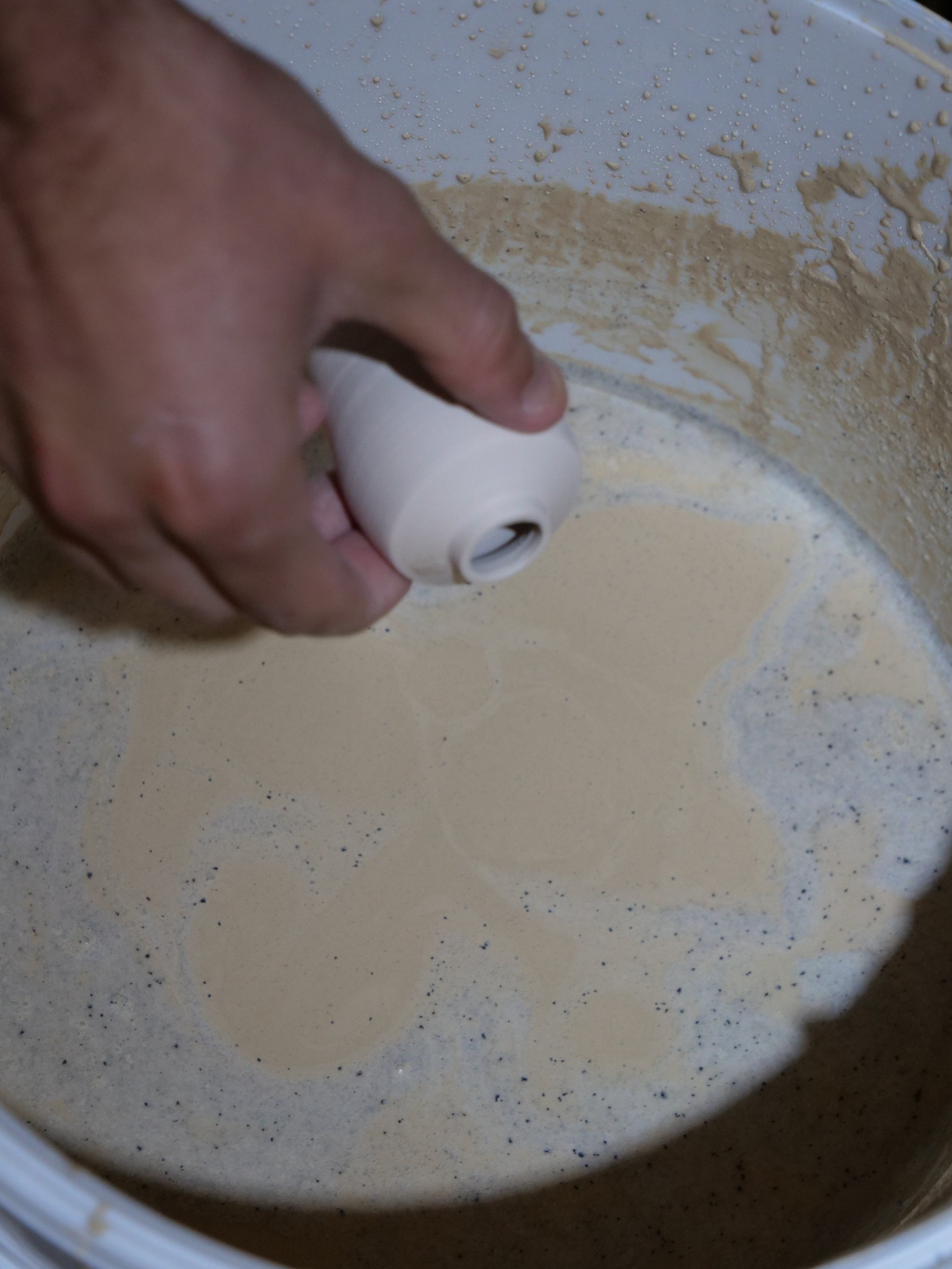A person pouring dry ingredients into a large mixing bowl.