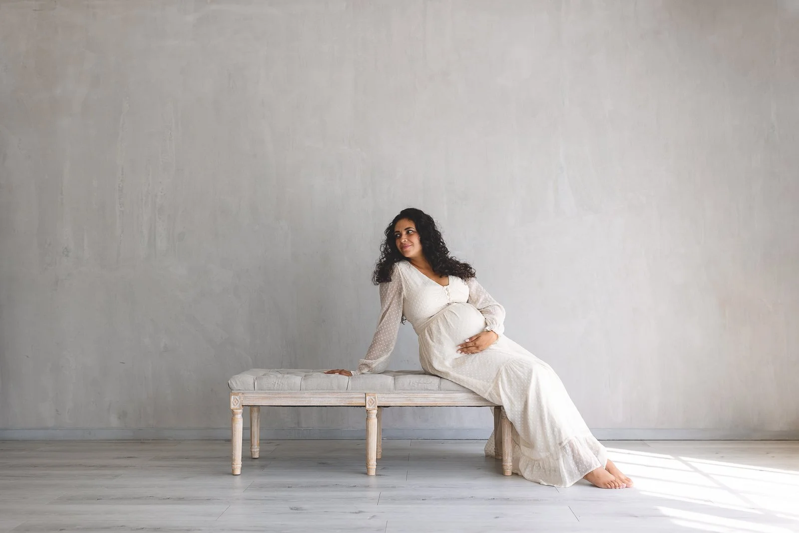 Orange County maternity photographer capturing a studio maternity portrait of an expecting mom in soft natural light.