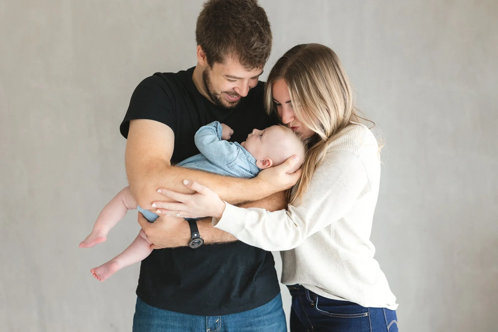 Family of three holding their baby during a studio photo session in Orange County.