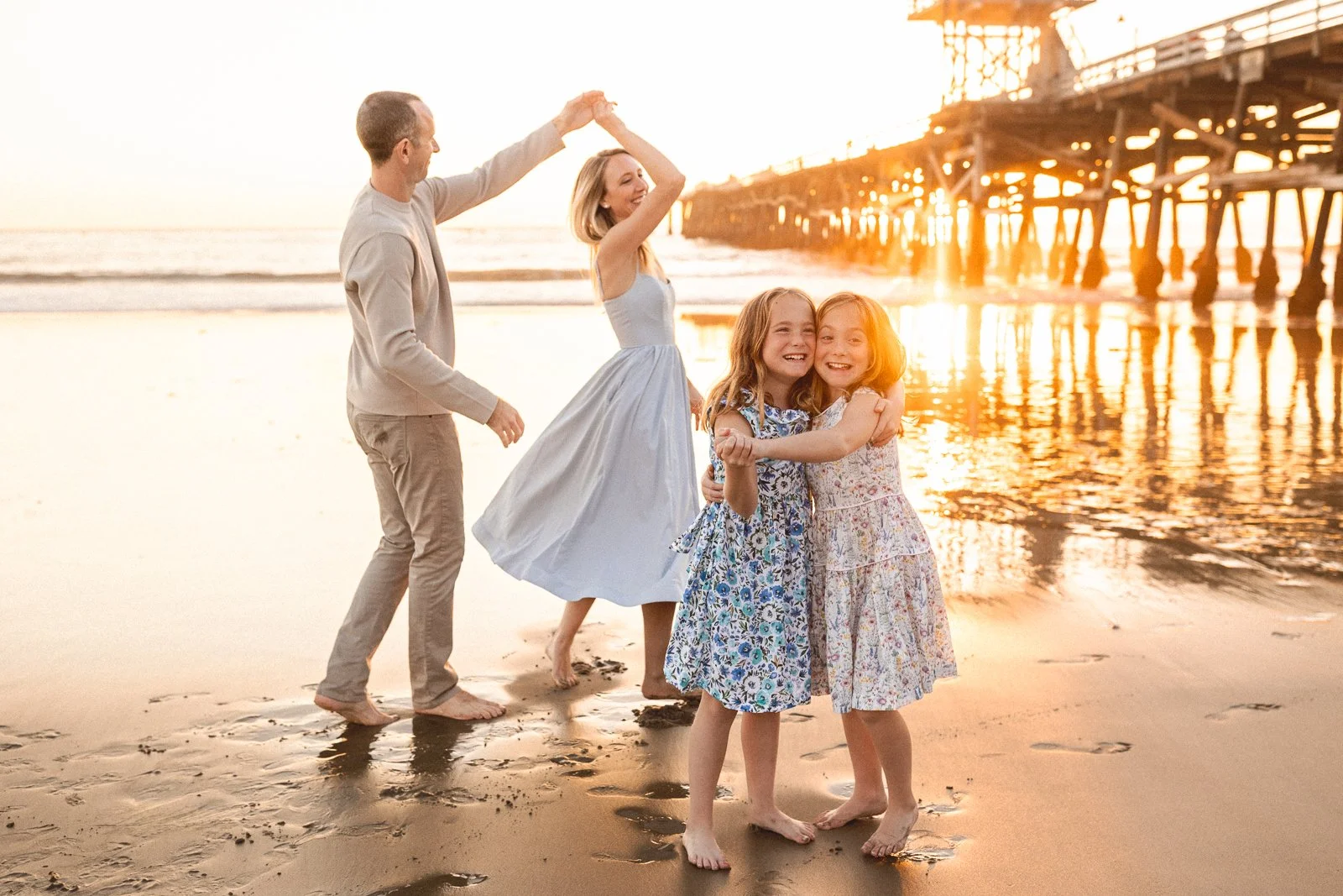 Orange County family photographer capturing a sunset beach session with kids near the pier.
