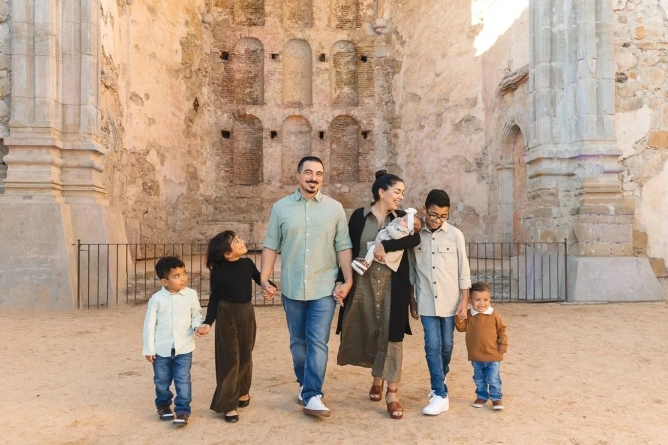 Orange County family photographer capturing a family walking together at a historic mission.