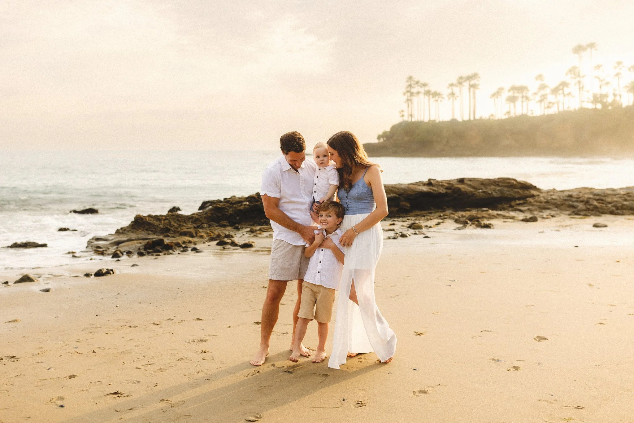 Orange County family photographer session with mom, dad, and two young boys at the beach during golden hour