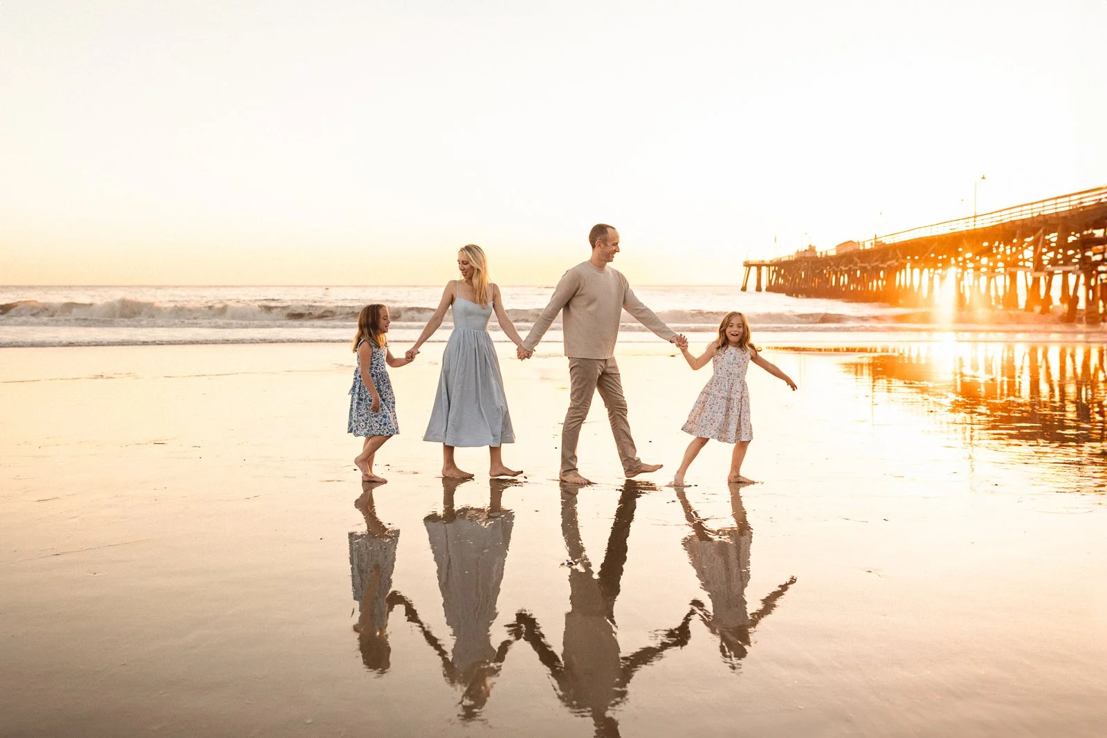 family walking on beach during photoshoot with orange county photographer
