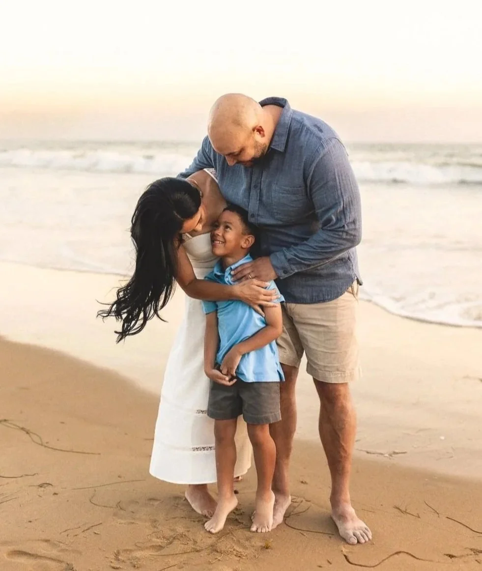 Group walking along the wet sand at Crystal Cove with rocky shoreline in the background during golden hour.