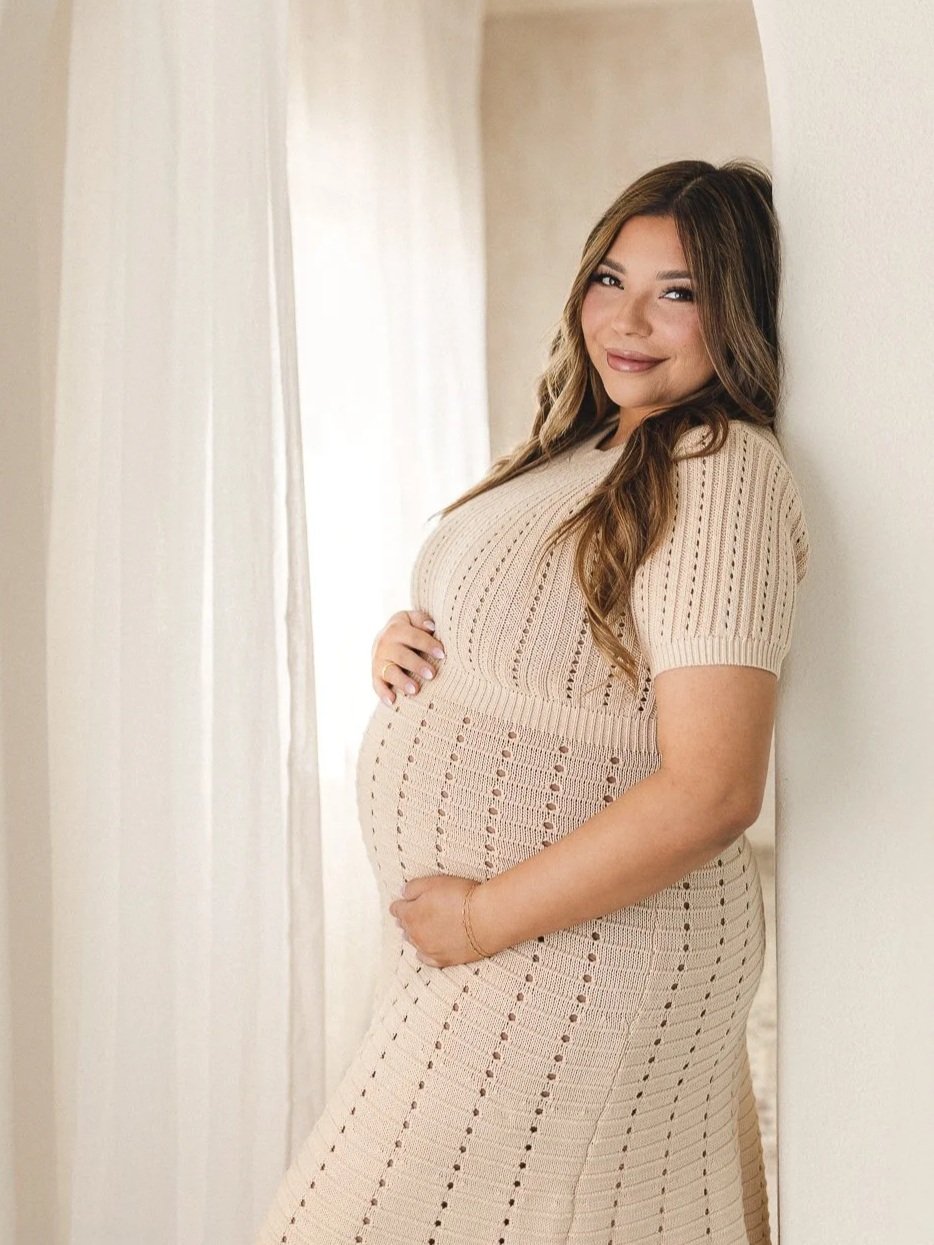 Studio maternity portrait in window light with an expecting mom in a knit dress