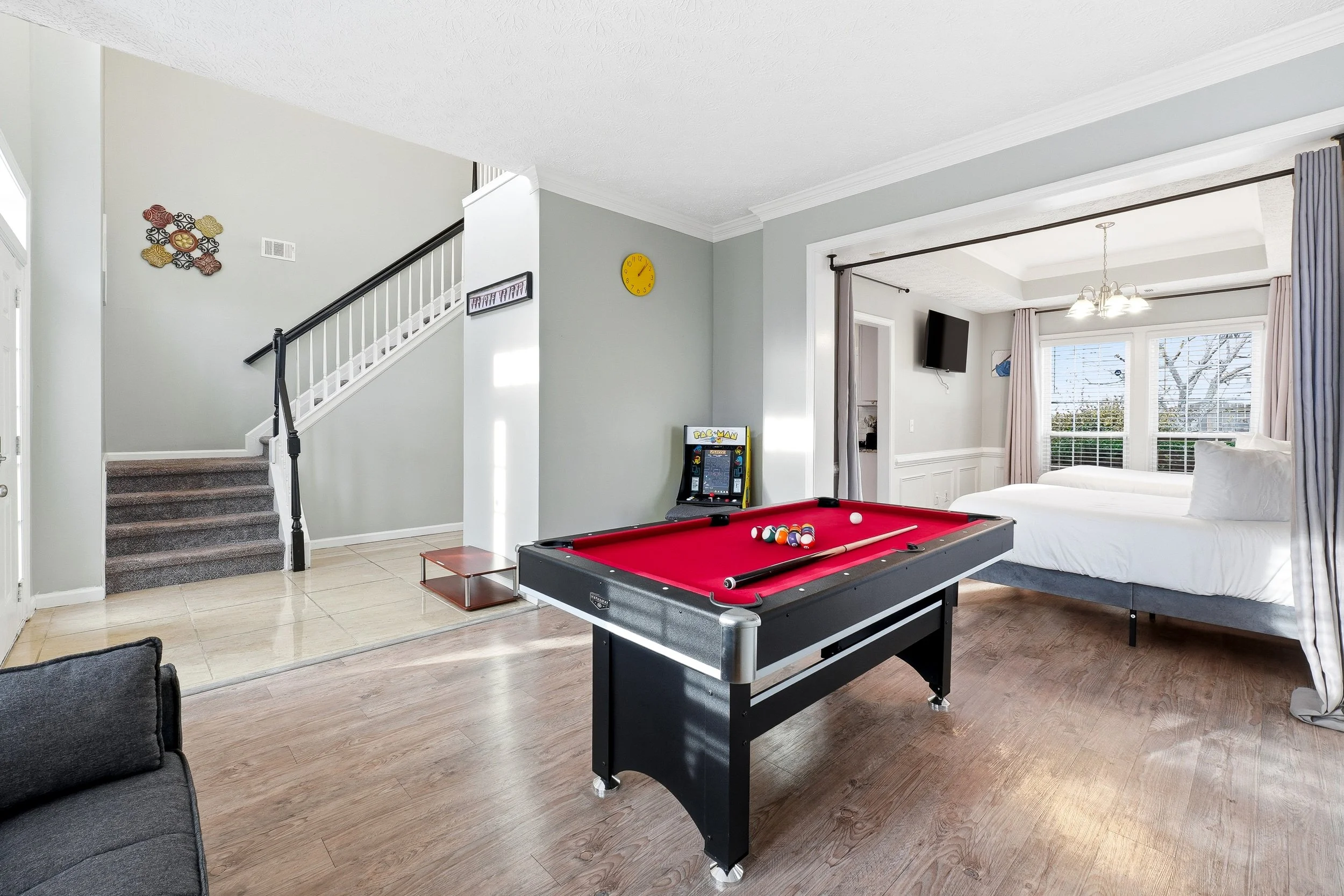 Full game room with a pool table, arcade games, and a comfortable sofa bed for extra sleeping space