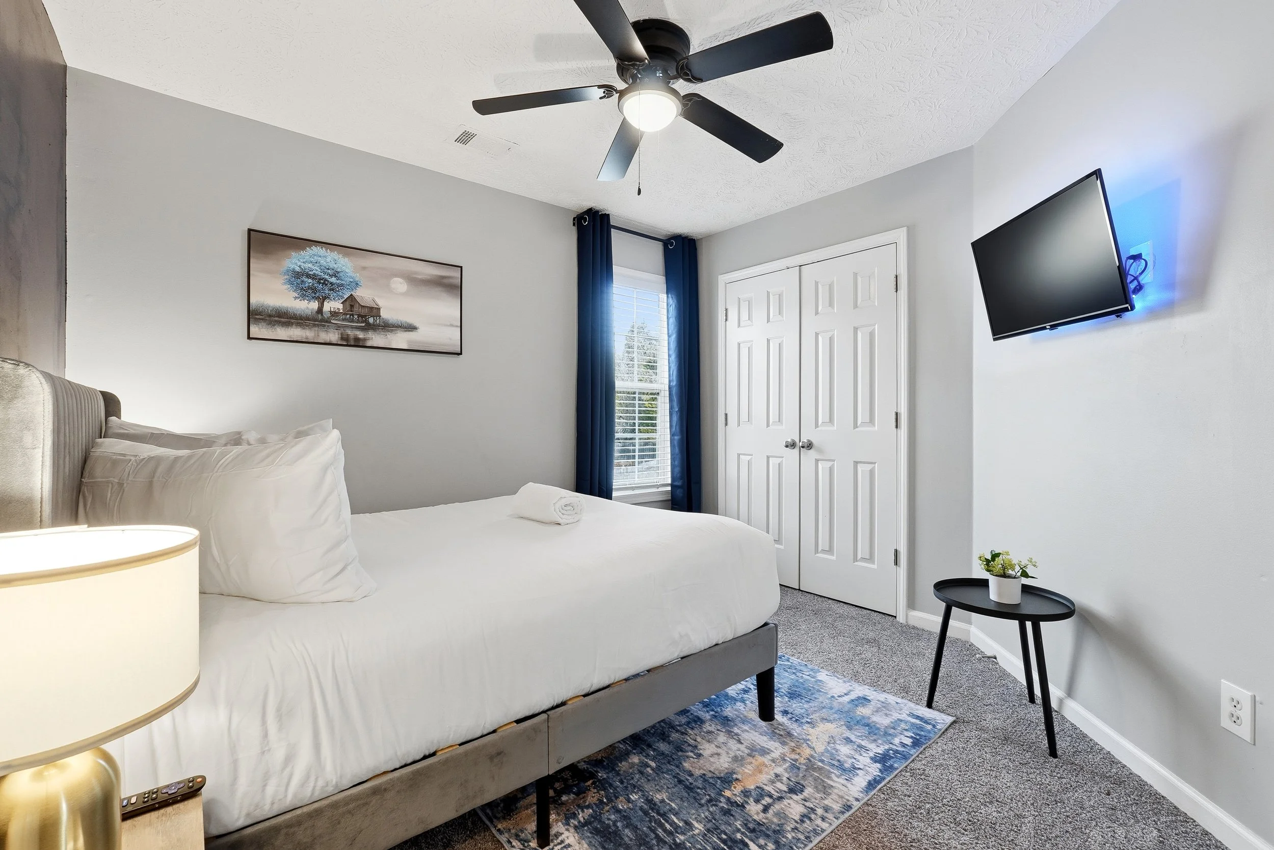 Cozy Queen Bedroom with blackout curtains, Smart TV, and soft, inviting bedding.