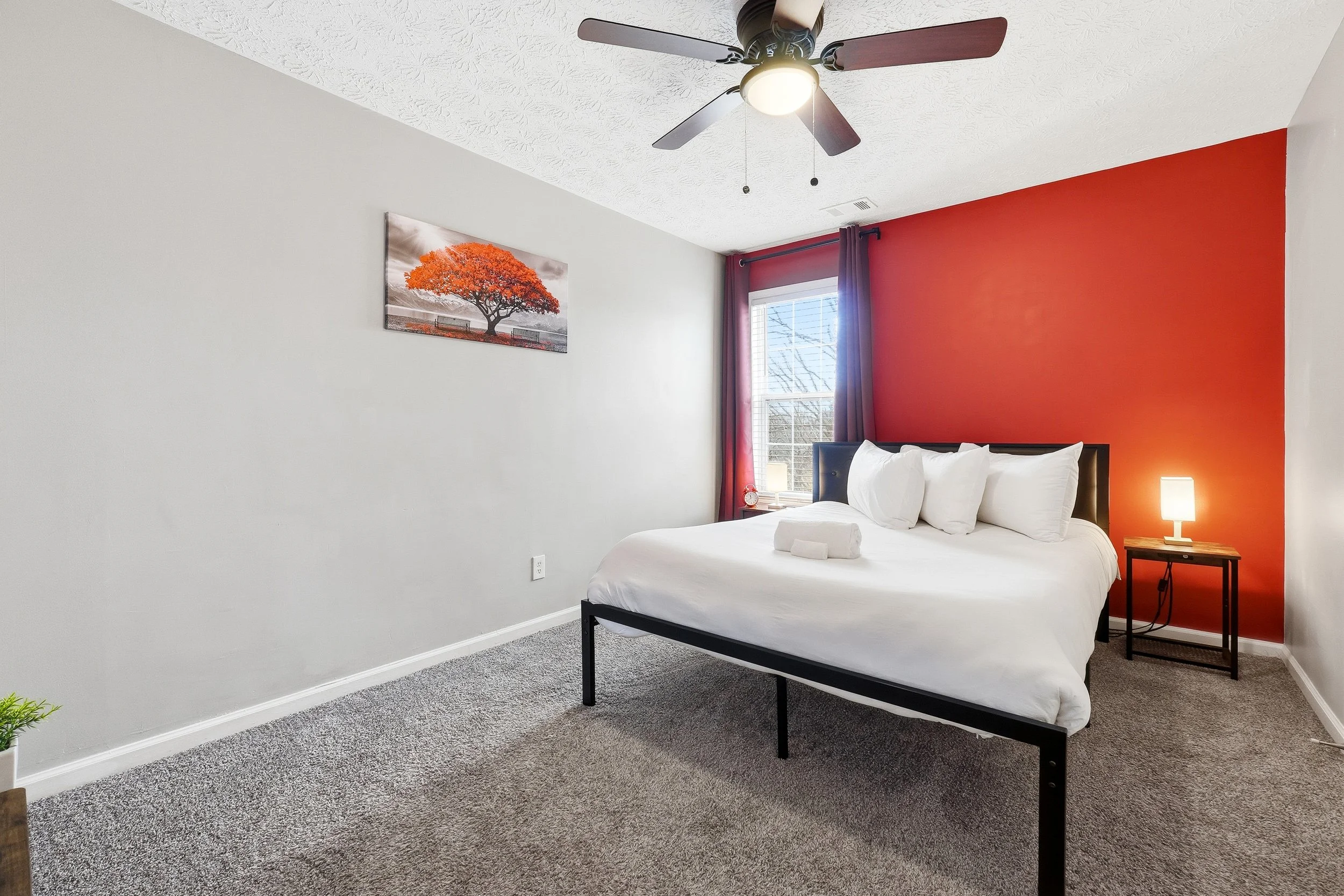 This inviting queen bedroom features dark blackout curtains, warm lighting, & a comfortable queen-size bed with fresh linens. Enjoy a 60-inch TV, bedside lamps with USB charging ports, and a peaceful atmosphere perfect for relaxing after a long day.