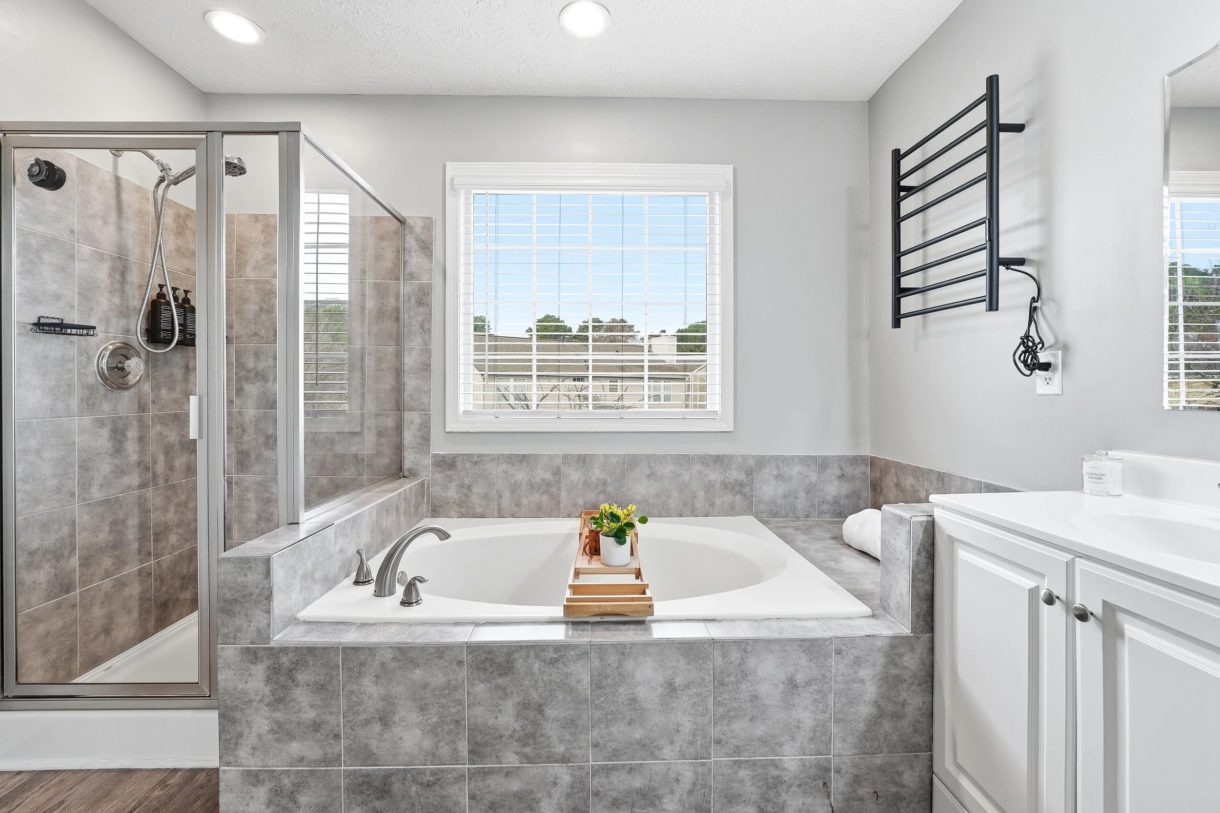 Spacious ensuite bathroom featuring a garden tub and heated towel racks