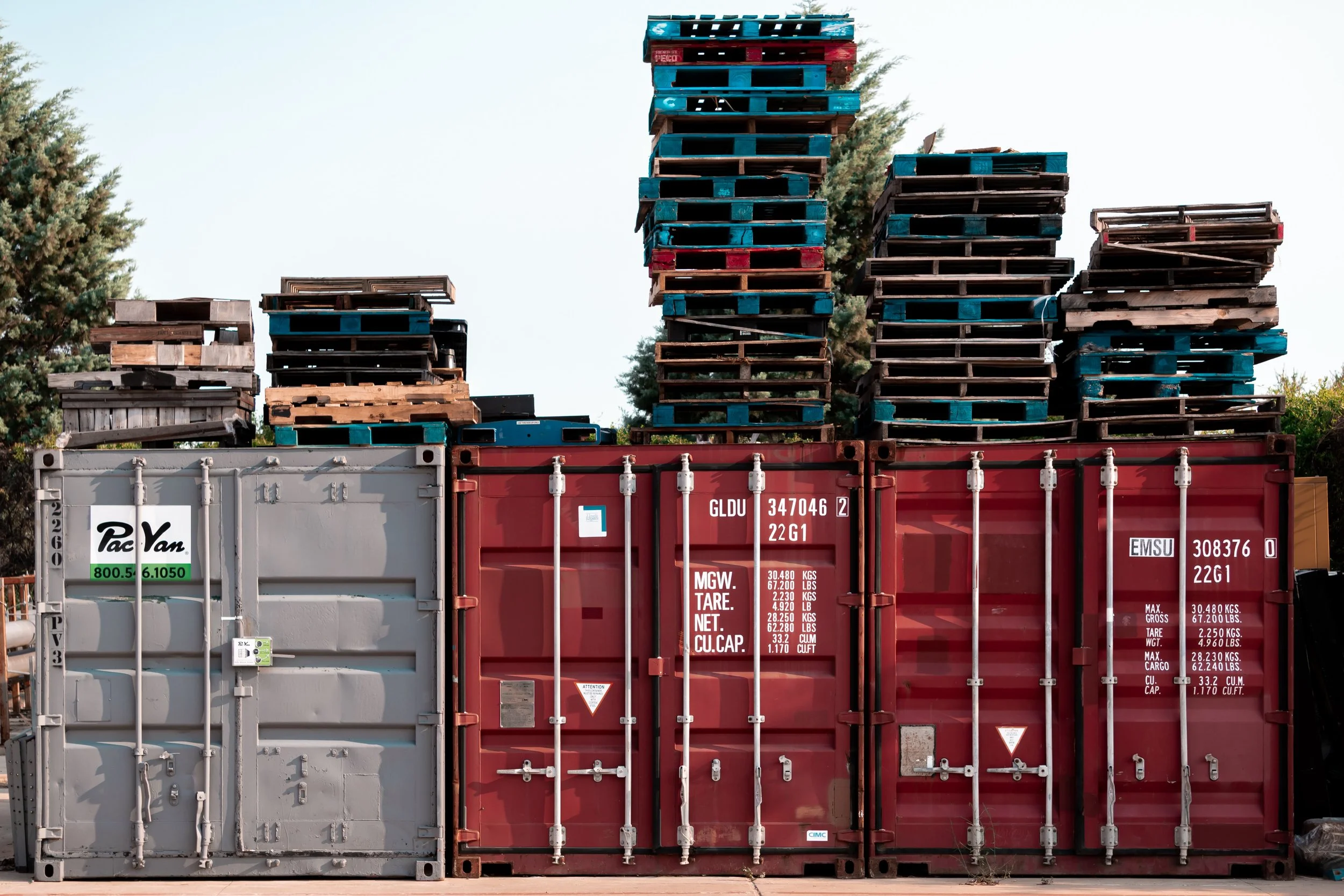 Stacked wooden pallets on top of shipping containers.