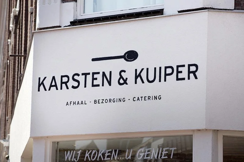Winkelbord met de tekst 'Karsten & Kuiper' en ondertitels 'afhaal, bezorging, catering'.