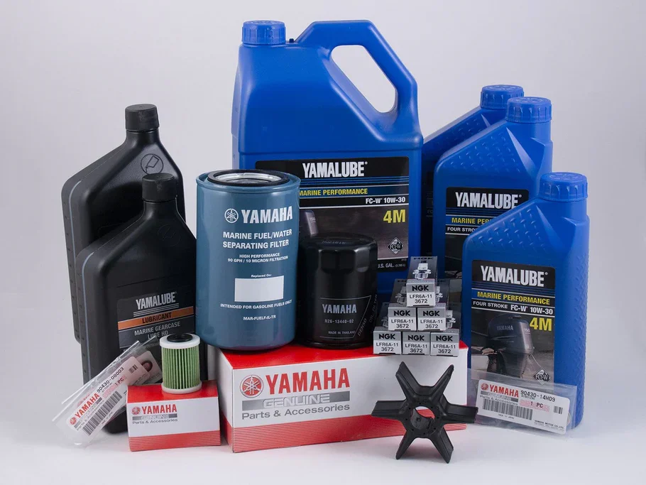 Assorted Yamaha and Yamalube marine engine oil and fuel filters, oil containers, spark plugs, and a water separating filter, arranged on a white background.