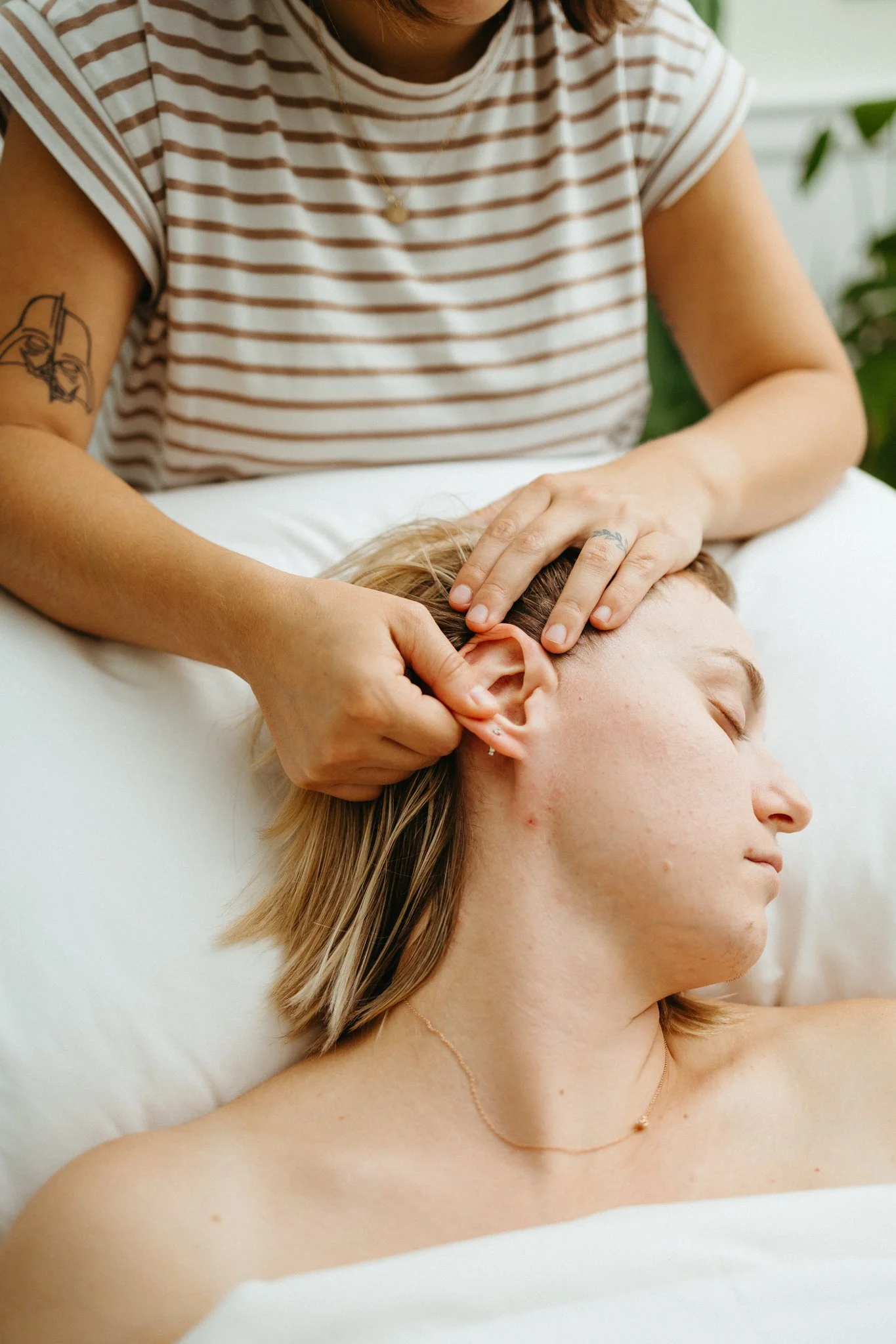 Shannon performing facial massage with ear stretches to promote lymphatic drainage