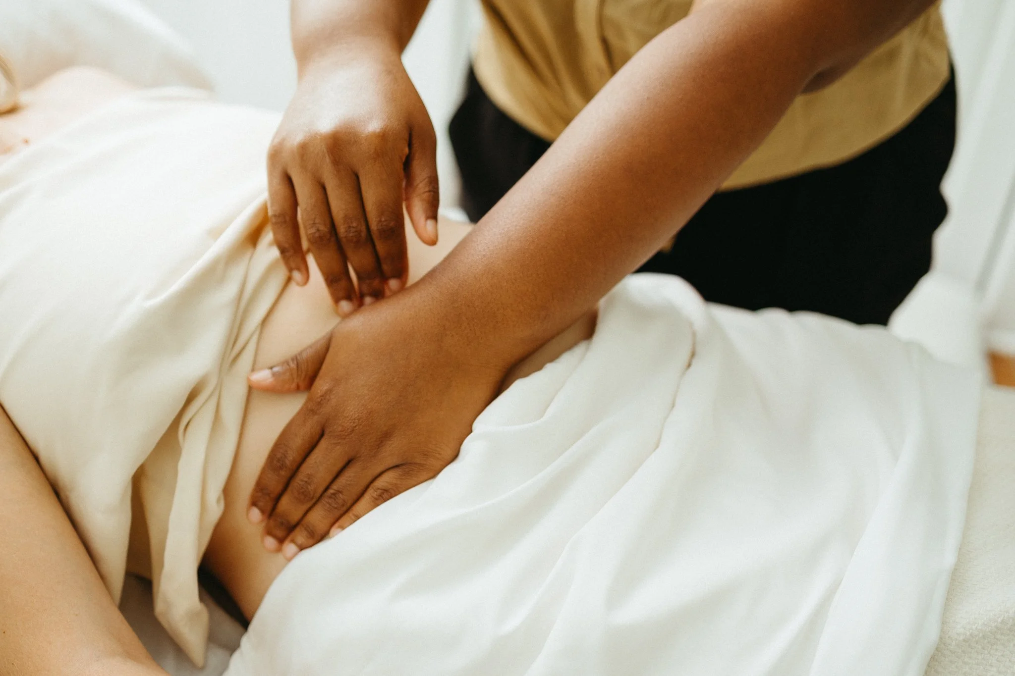 Lydia performing abdominal massage to help with round ligament and low back pain during pregnancy